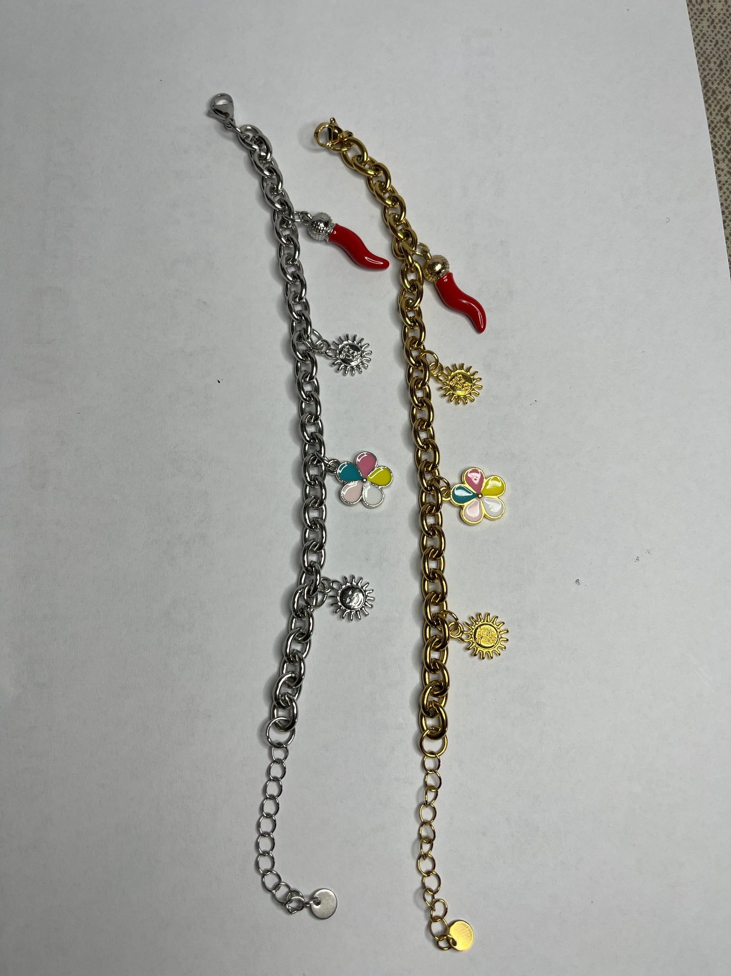Braccialetto Amuleto Chic con catene dorate e argentate e charm portafortuna a forma di sole, fiore e cornetto rosso