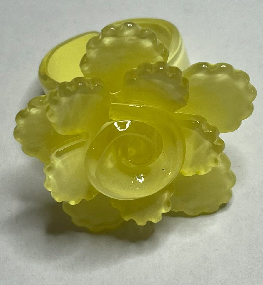 Anello Petalo di Primavera con fiore rosa tridimensionale in plastica colorata, disponibile in verde, rosa, rosso, giallo, bianco e nero, con petali scolpiti e finitura lucida