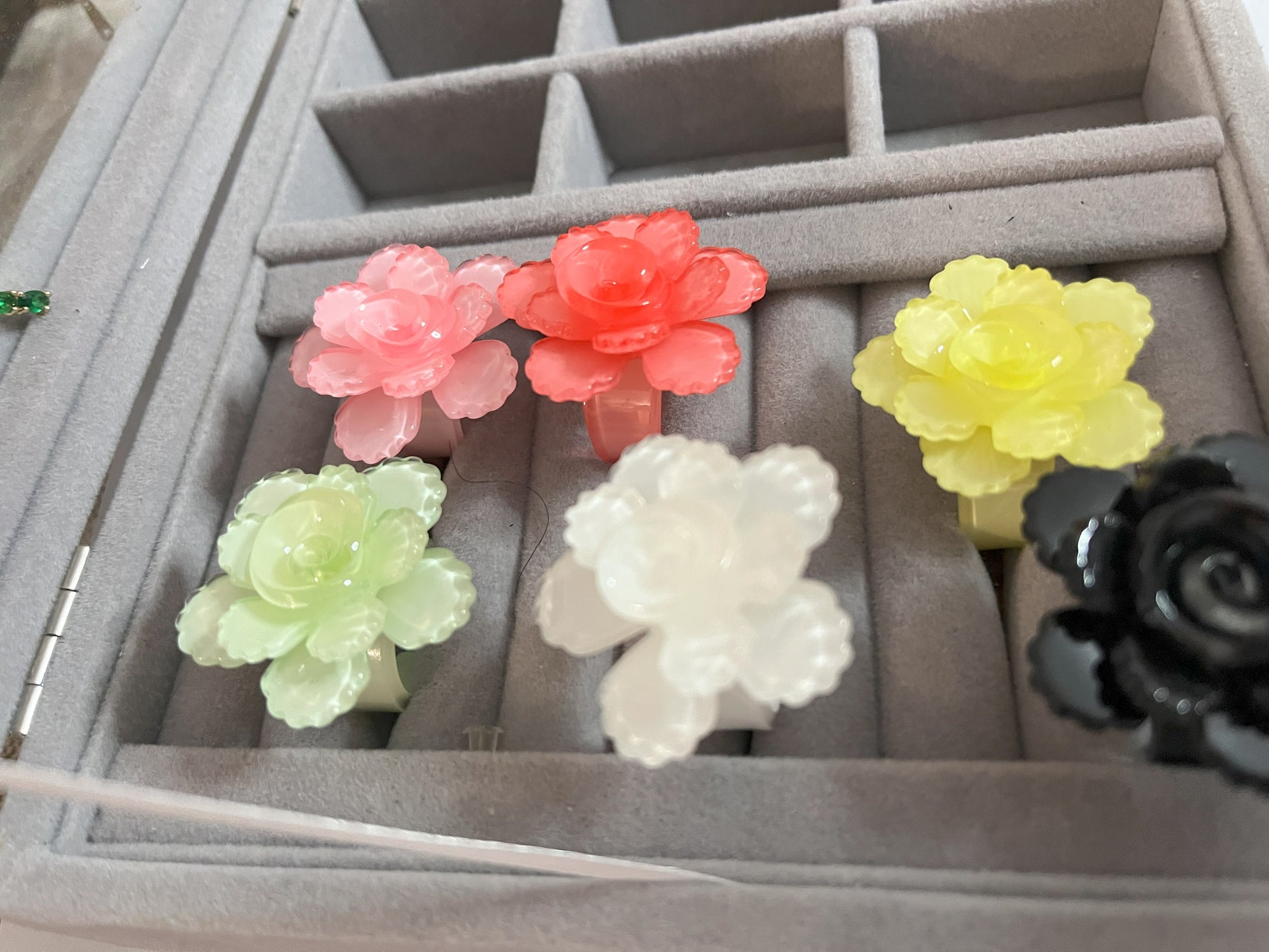 Anello Petalo di Primavera con fiore rosa tridimensionale in plastica colorata, disponibile in verde, rosa, rosso, giallo, bianco e nero, con petali scolpiti e finitura lucida