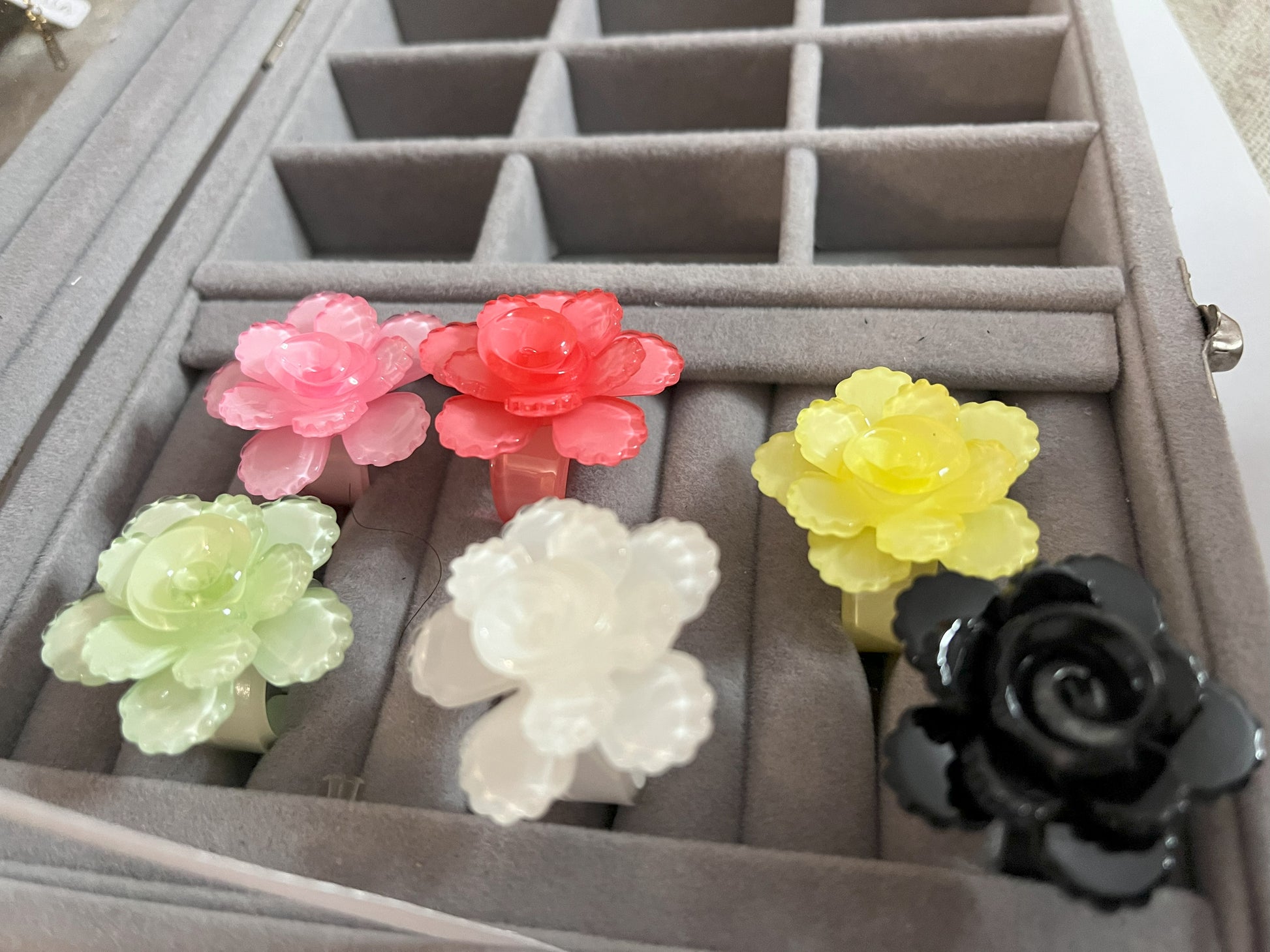 Anello Petalo di Primavera con fiore rosa tridimensionale in plastica colorata, disponibile in verde, rosa, rosso, giallo, bianco e nero, con petali scolpiti e finitura lucida