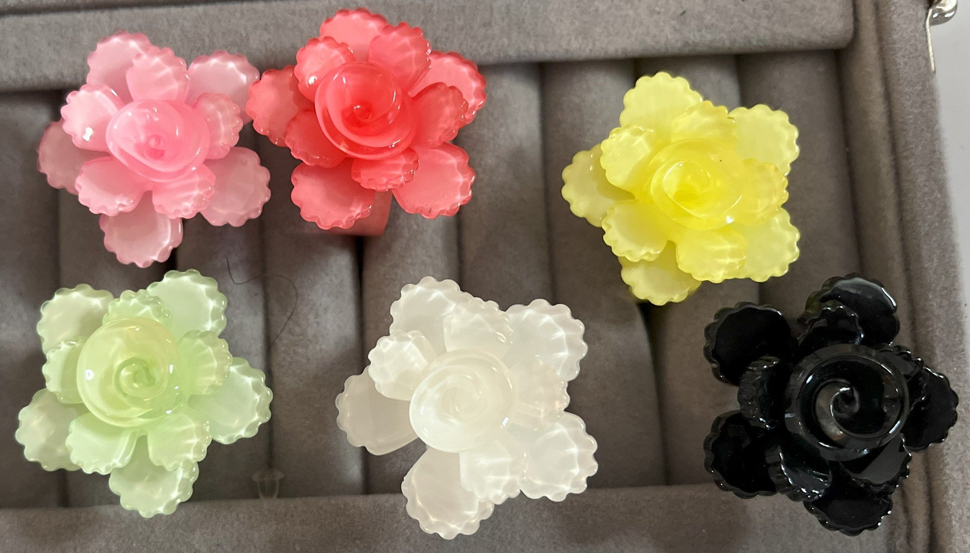 Anello Petalo di Primavera con fiore rosa tridimensionale in plastica colorata, disponibile in verde, rosa, rosso, giallo, bianco e nero, con petali scolpiti e finitura lucida