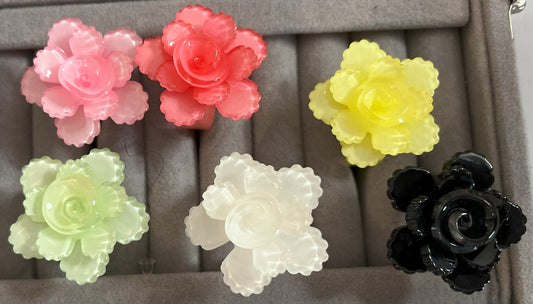 Anello Petalo di Primavera con fiore rosa tridimensionale in plastica colorata, disponibile in verde, rosa, rosso, giallo, bianco e nero, con petali scolpiti e finitura lucida