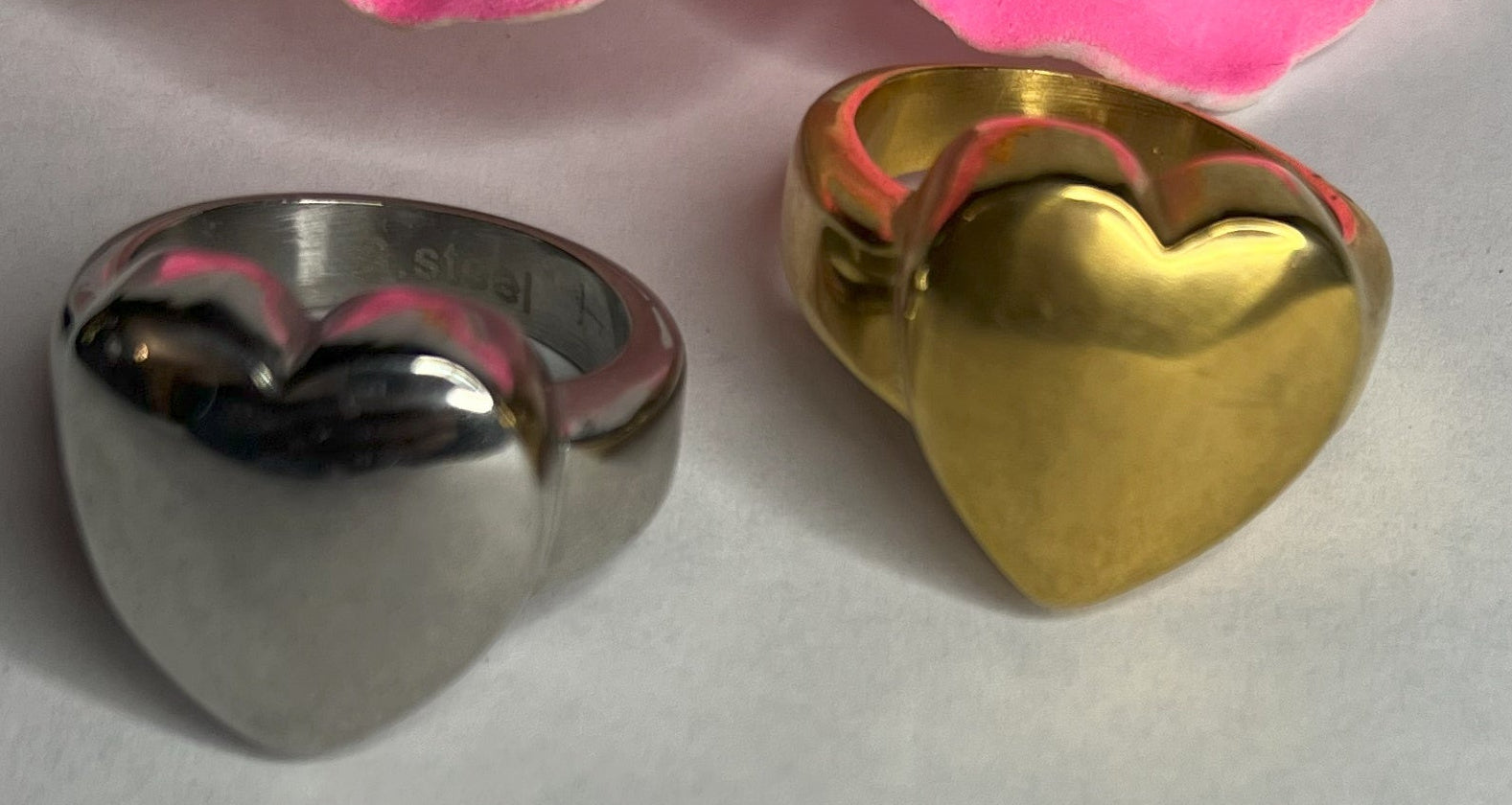 Anello Cuore Eterno con design bombato arrotondato, disponibile in versione placcata oro e argento su fiore rosa decorativo