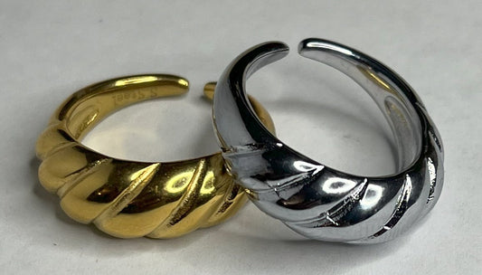 Anello con design intrecciato placcato oro, texture tridimensionale su sfondo neutro