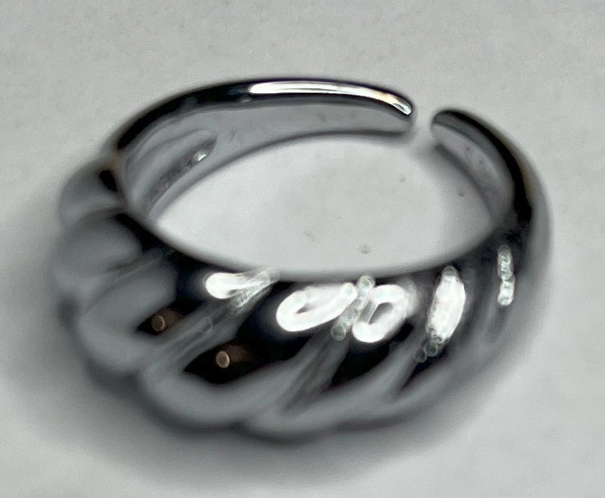 Anello con design intrecciato placcato oro, texture tridimensionale su sfondo neutro