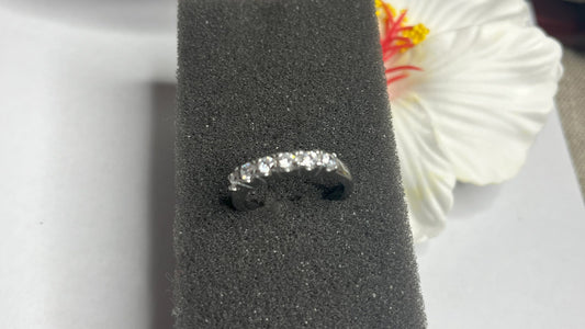 Anello Quintessenza d'Amore con cinque diamanti brillanti incastonati in acciaio di alta qualità placcato argento, fotografato su sfondo nero vellutato