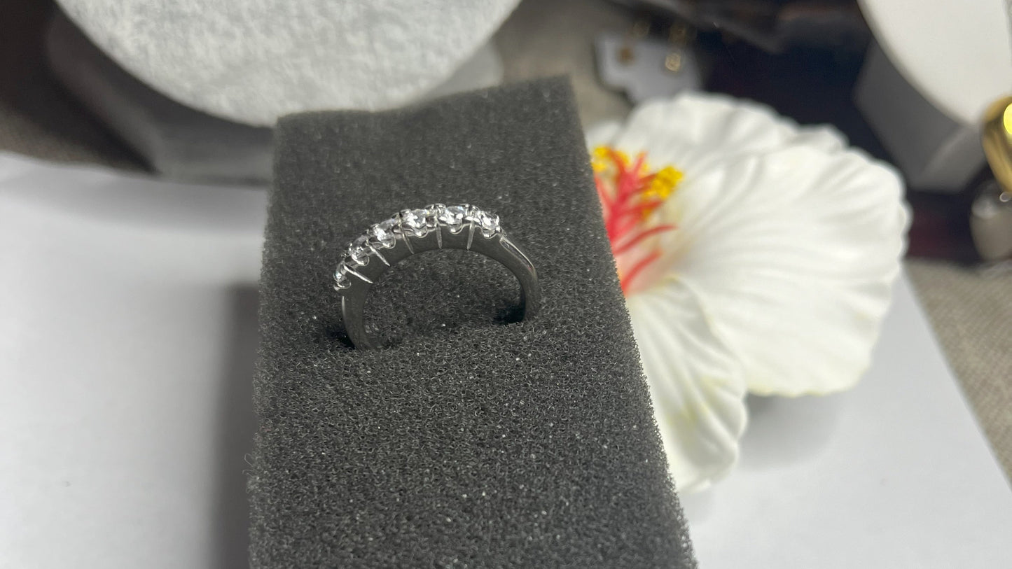 Anello Quintessenza d'Amore con cinque diamanti brillanti incastonati in acciaio di alta qualità placcato argento, fotografato su sfondo nero vellutato