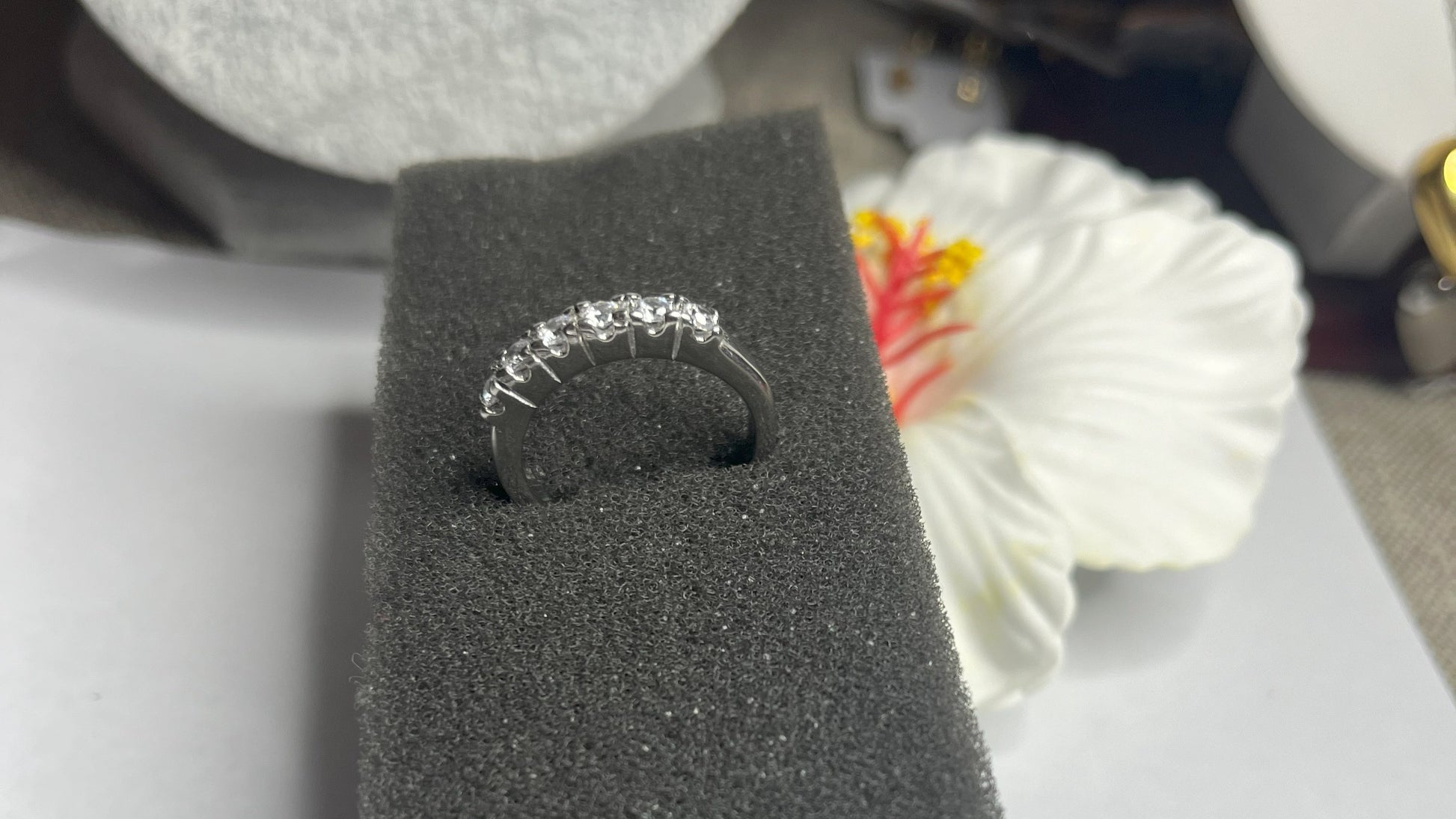 Anello Quintessenza d'Amore con cinque diamanti brillanti incastonati in acciaio di alta qualità placcato argento, fotografato su sfondo nero vellutato