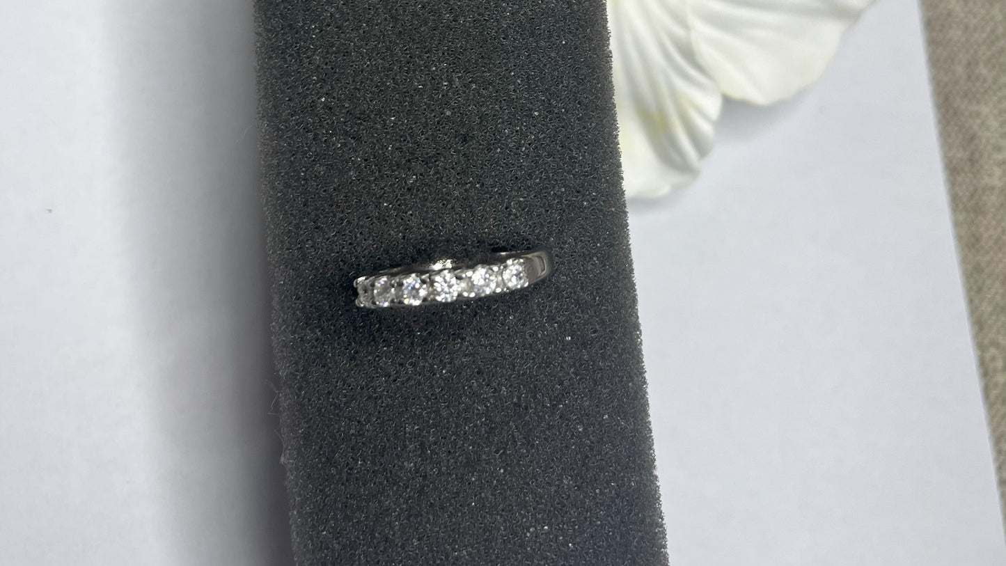 Anello Quintessenza d'Amore con cinque diamanti brillanti incastonati in acciaio di alta qualità placcato argento, fotografato su sfondo nero vellutato