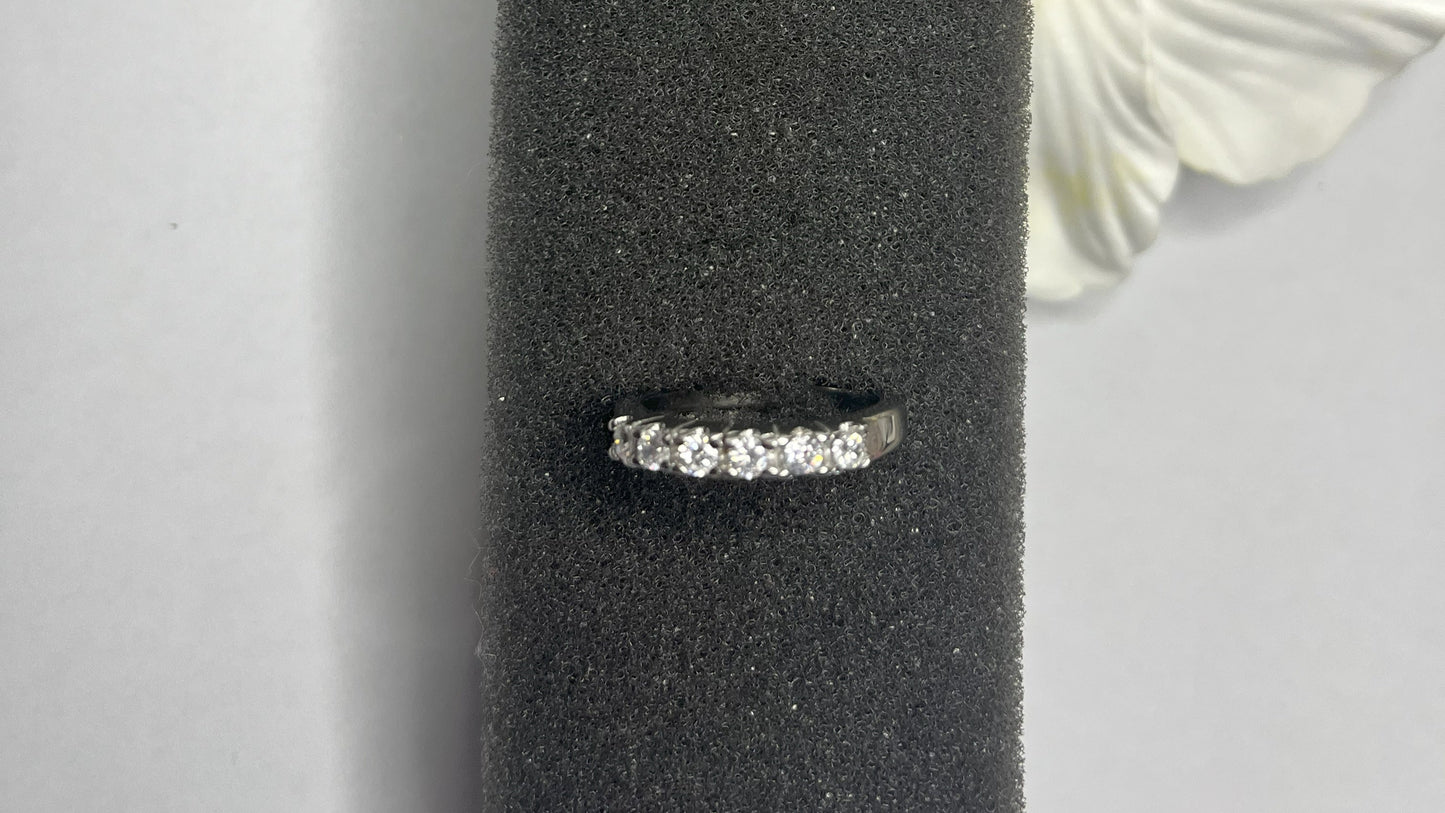 Anello Quintessenza d'Amore con cinque diamanti brillanti incastonati in acciaio di alta qualità placcato argento, fotografato su sfondo nero vellutato