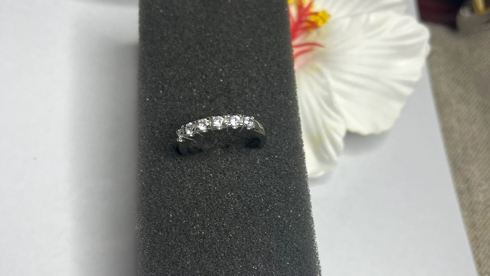 Anello Quintessenza d'Amore con cinque diamanti brillanti incastonati in acciaio di alta qualità placcato argento, fotografato su sfondo nero vellutato