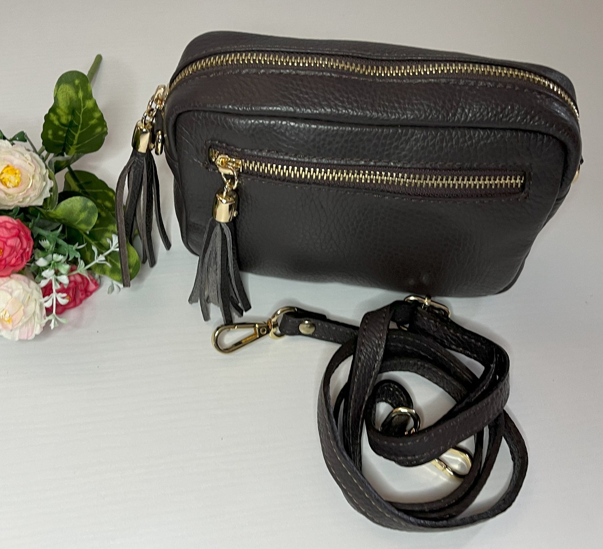 Borsa Mogano Premium in vera pelle testa di moro Made in Italy con doppia cerniera dorata, nappa decorativa e tracolla intrecciata regolabile, fotografata su superficie bianca