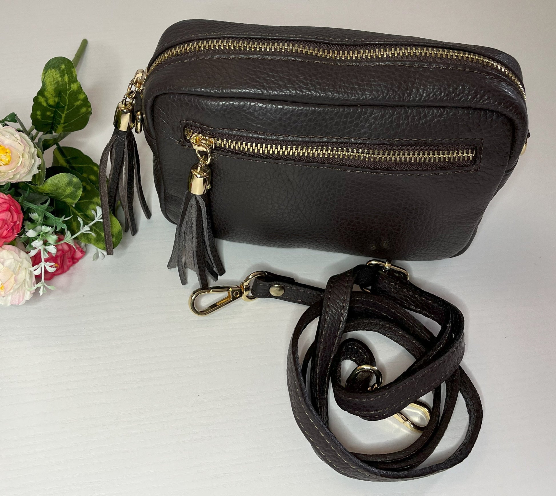 Borsa Mogano Premium in vera pelle testa di moro Made in Italy con doppia cerniera dorata, nappa decorativa e tracolla intrecciata regolabile, fotografata su superficie bianca
