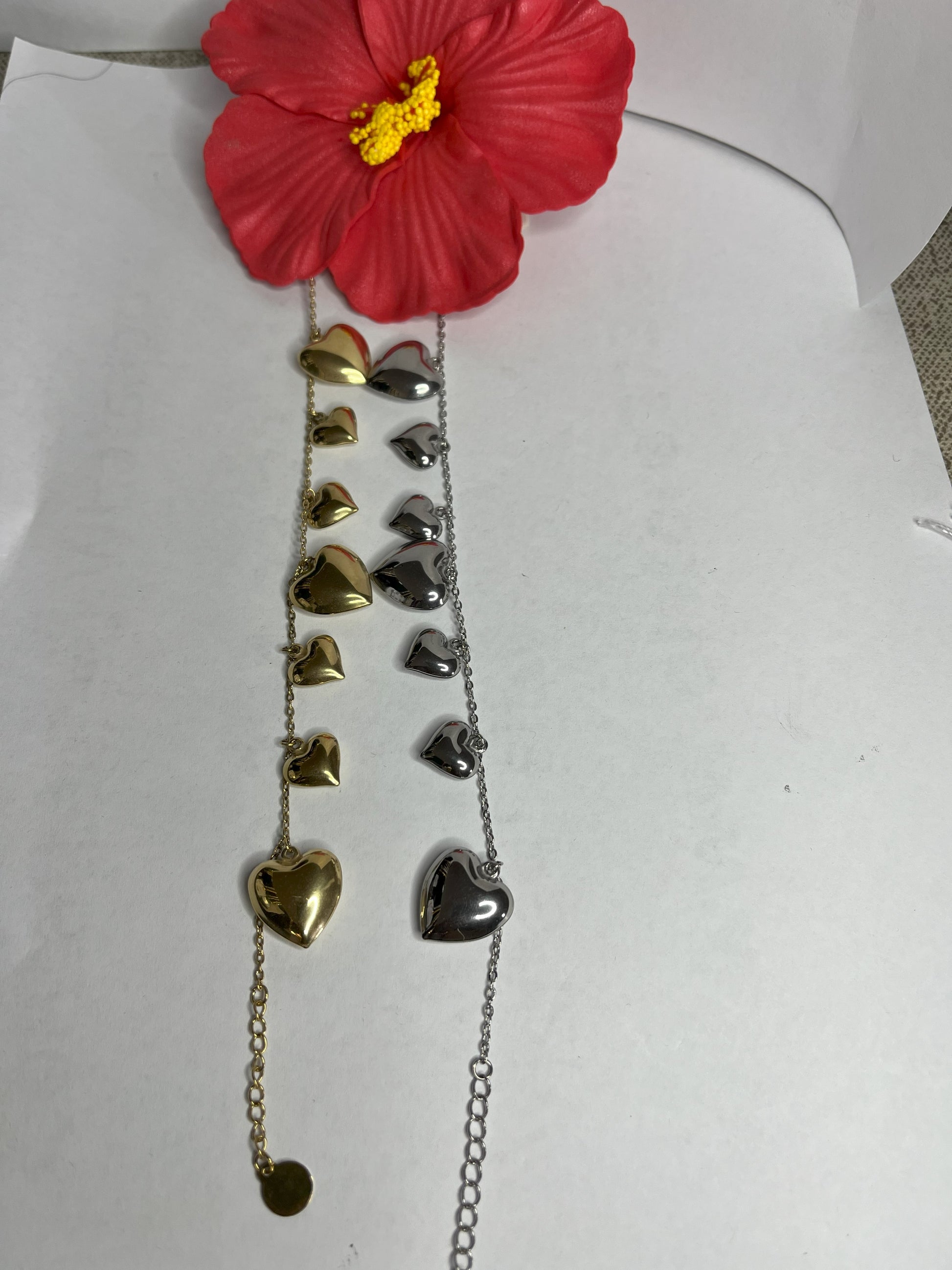 Braccialetto Cuori a Sonagli placcato oro e argento, con cuori pendenti che creano un suono melodioso, design romantico ed elegante.