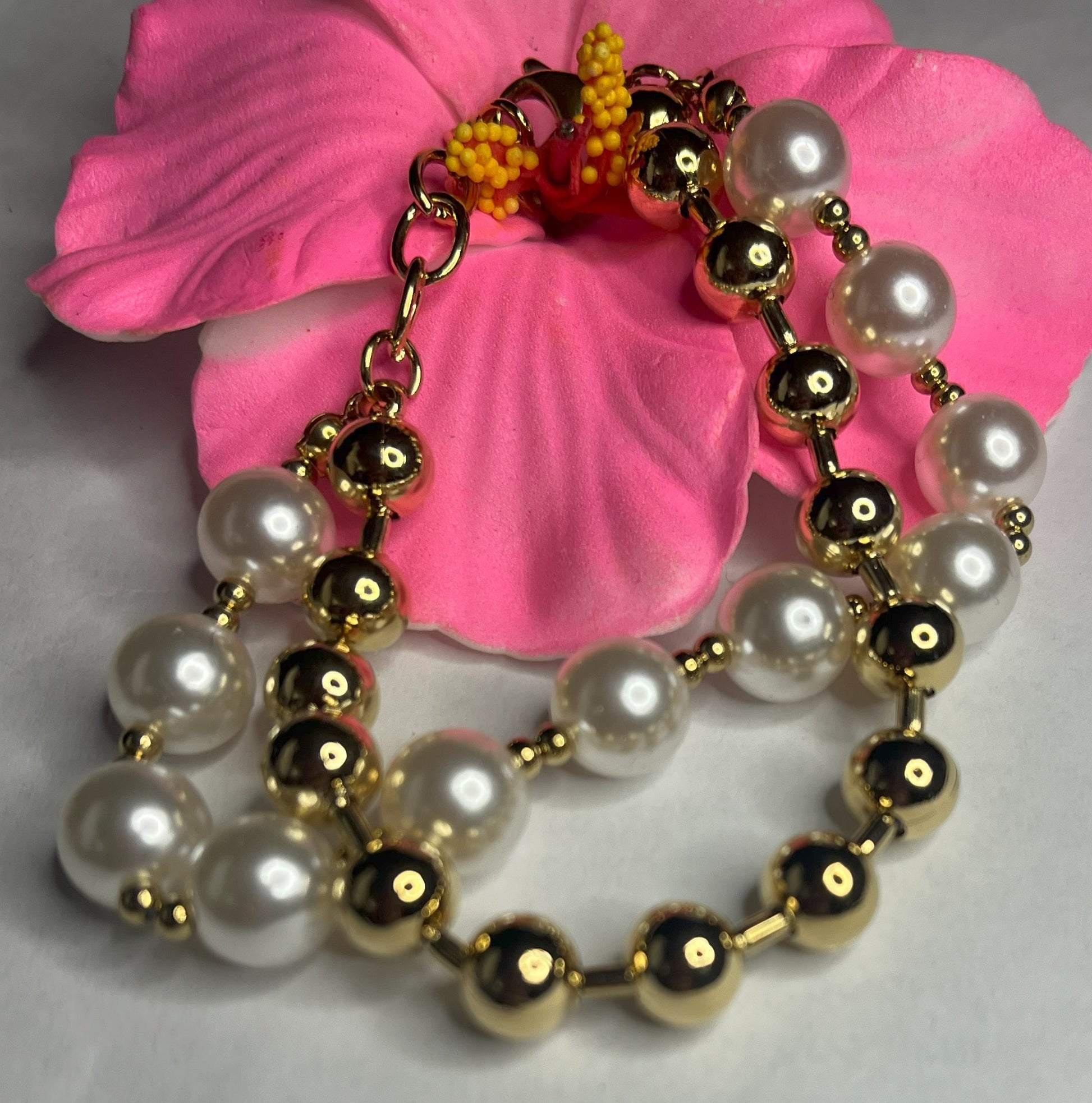 Braccialetto doppio eleganza dorata con sfere color oro e perlato su petali rosa