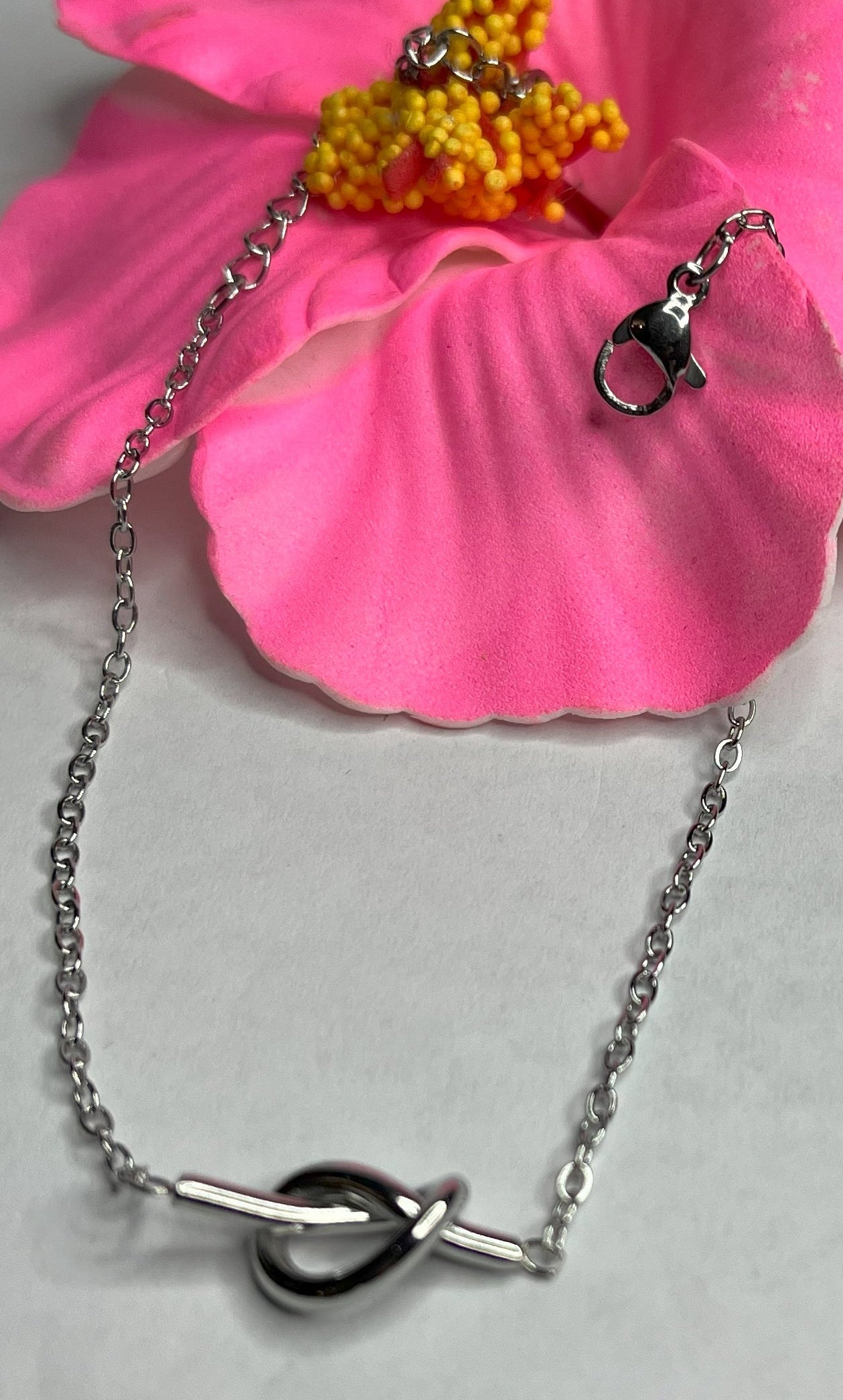 Braccialetto Giardino Magico in acciaio inox argentato con charms floreali, cuori rossi e perline colorate su sfondo grigio