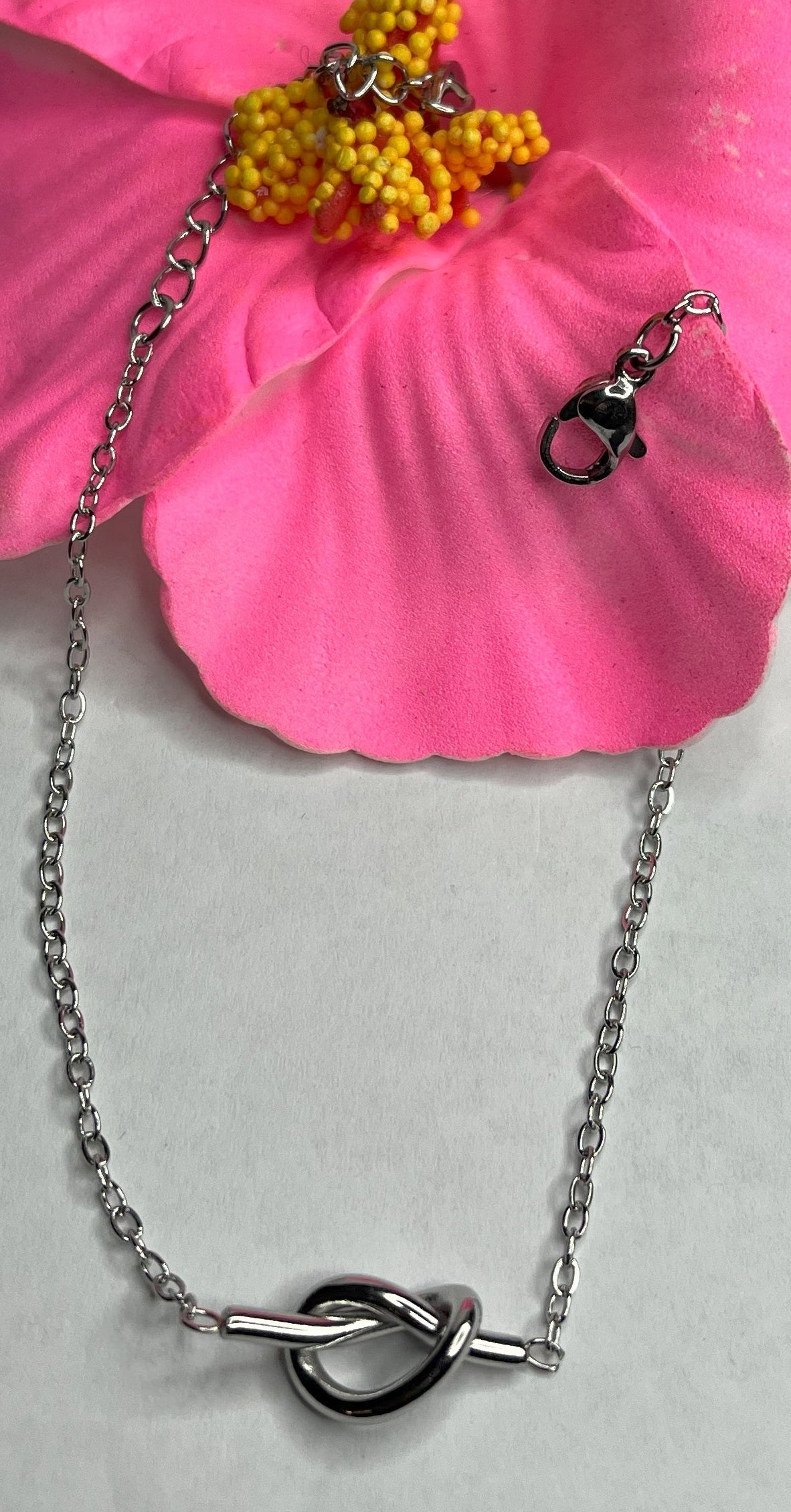 Braccialetto Giardino Magico in acciaio inox argentato con charms floreali, cuori rossi e perline colorate su sfondo grigio