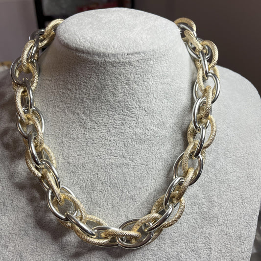 Collana Catena Eclipse in alluminio premium con anelli texturizzati dorati su busto espositore, design moderno con effetti luce-ombra