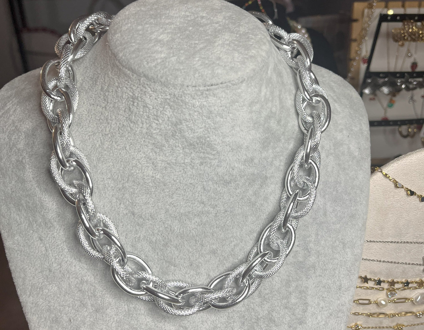 Collana Catena Eclipse in alluminio premium con anelli texturizzati argento su busto espositore, design moderno con effetti luce-ombra
