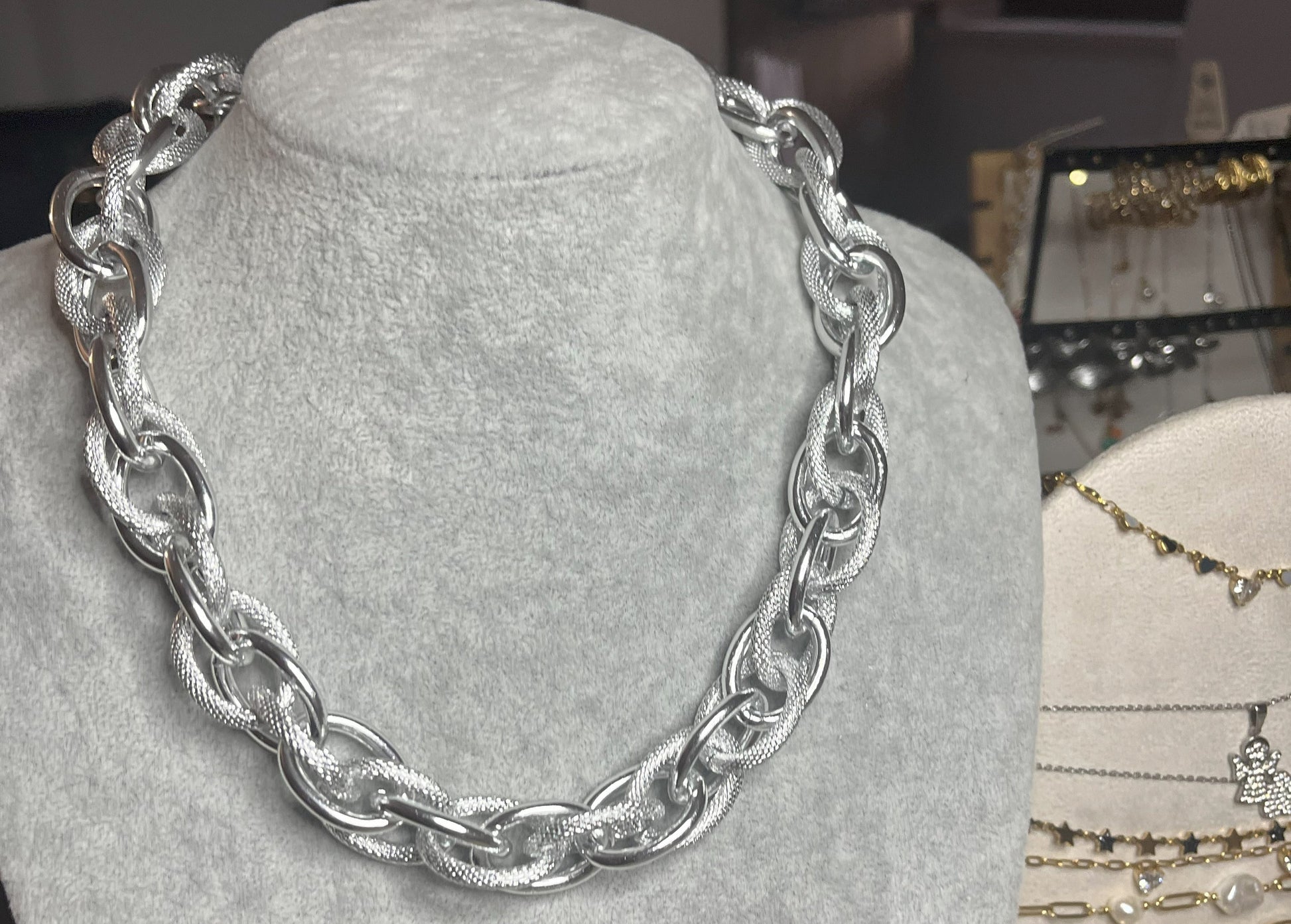 Collana Catena Eclipse in alluminio premium con anelli texturizzati argento su busto espositore, design moderno con effetti luce-ombra