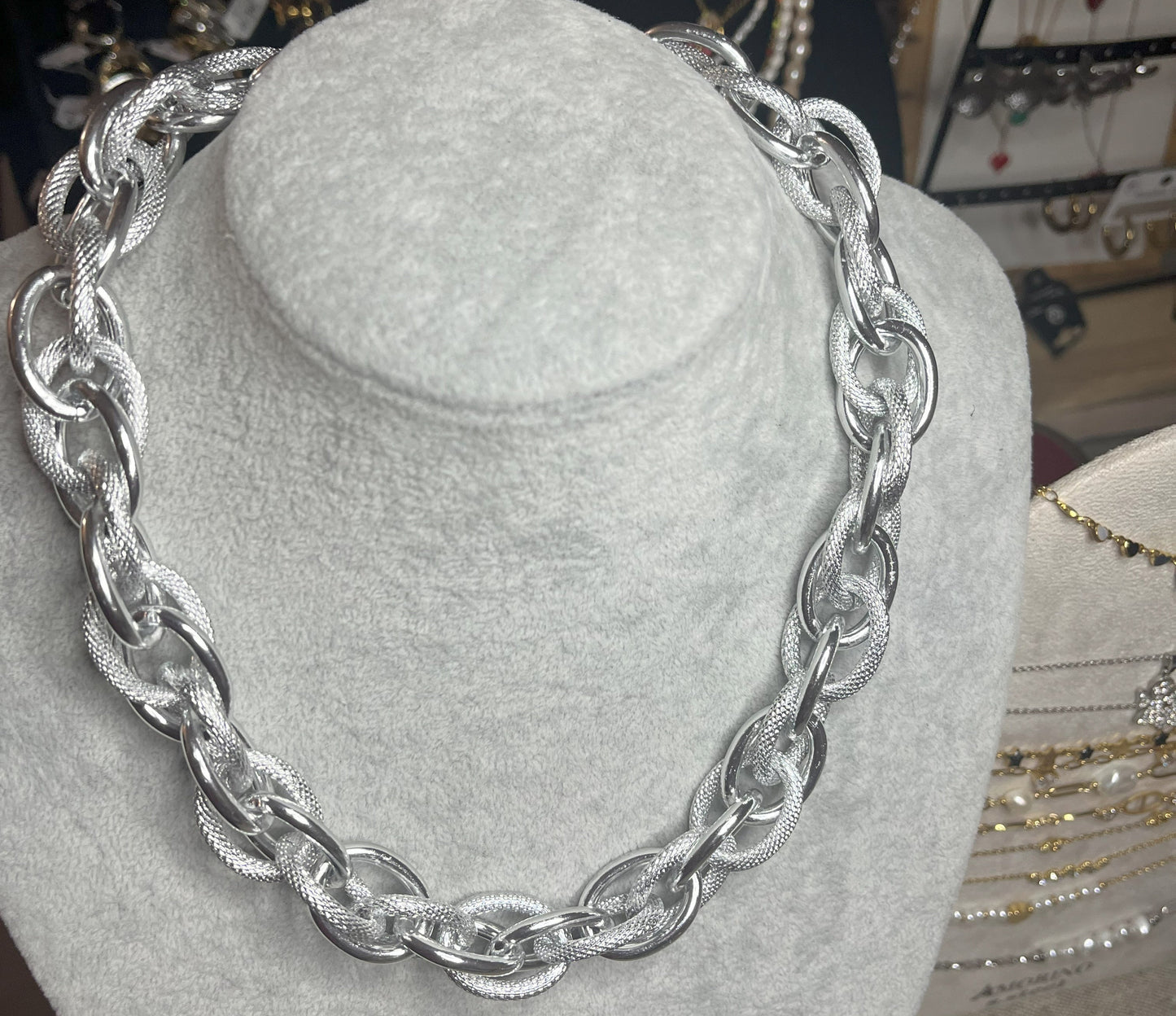 Collana Catena Eclipse in alluminio premium con anelli texturizzati argento su busto espositore, design moderno con effetti luce-ombra