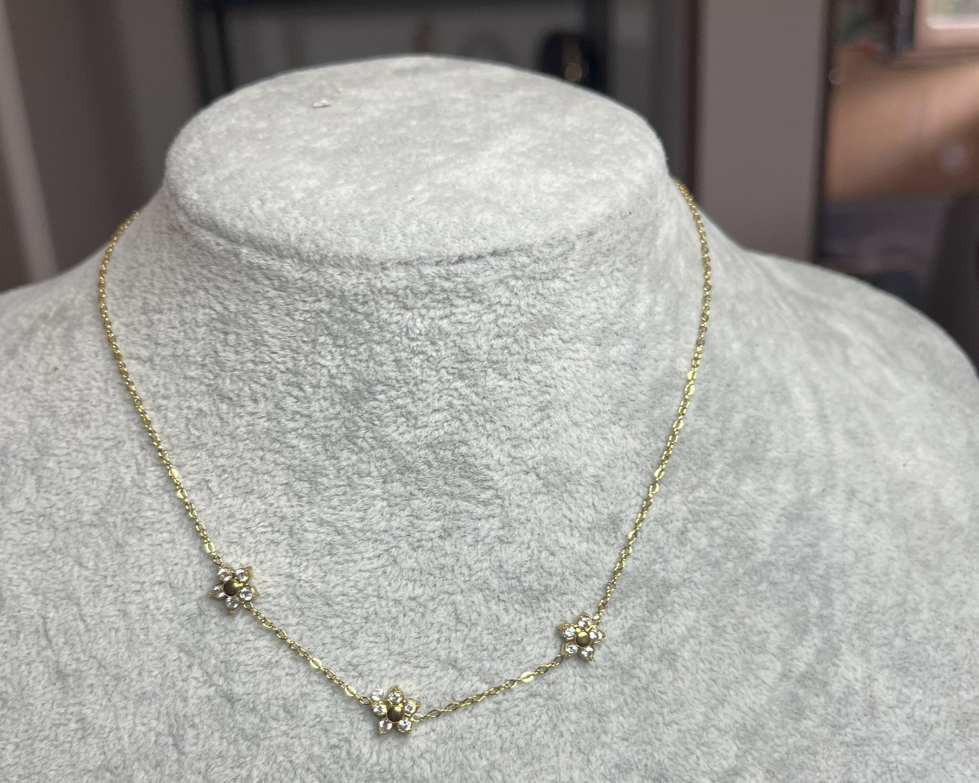 Collana 3 Margherite Dorate - elegante catena dorata con tre margherite brillanti, gioiello floreale su busto espositore