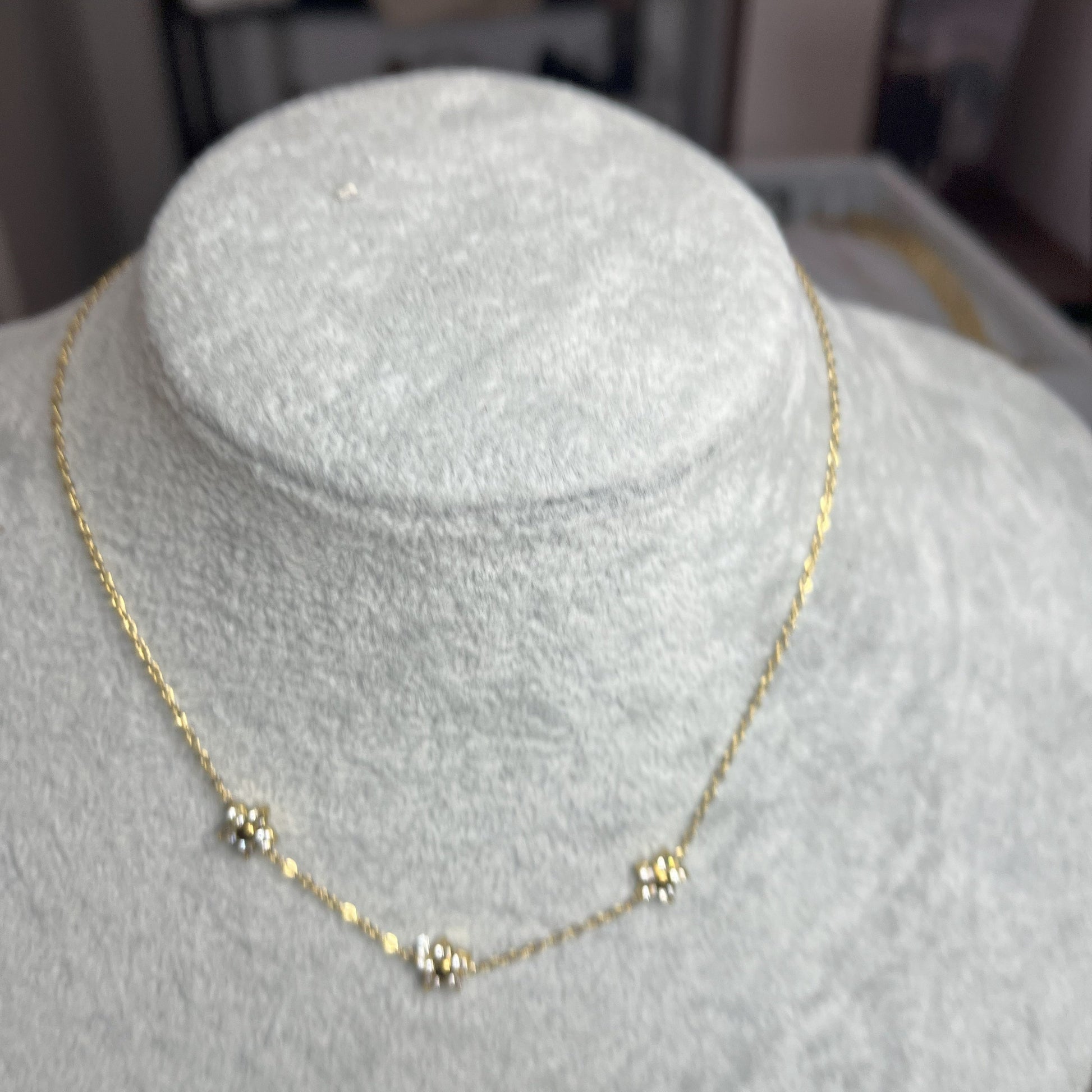 Collana 3 Margherite Dorate - elegante catena dorata con tre margherite brillanti, gioiello floreale su busto espositore