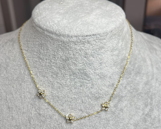 Collana 3 Margherite Dorate - elegante catena dorata con tre margherite brillanti, gioiello floreale su busto espositore