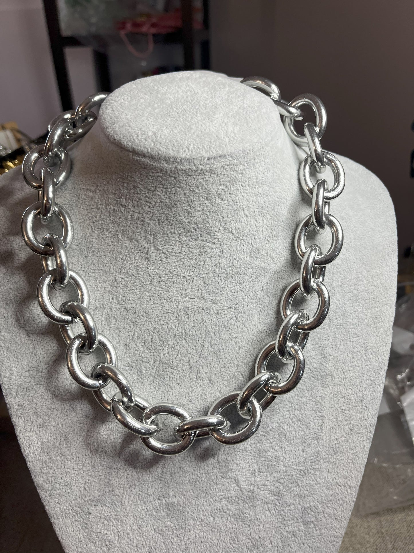 Collana Catena Armonia in alluminio premium con anelli argentati intrecciati su busto espositore, design moderno e elegante