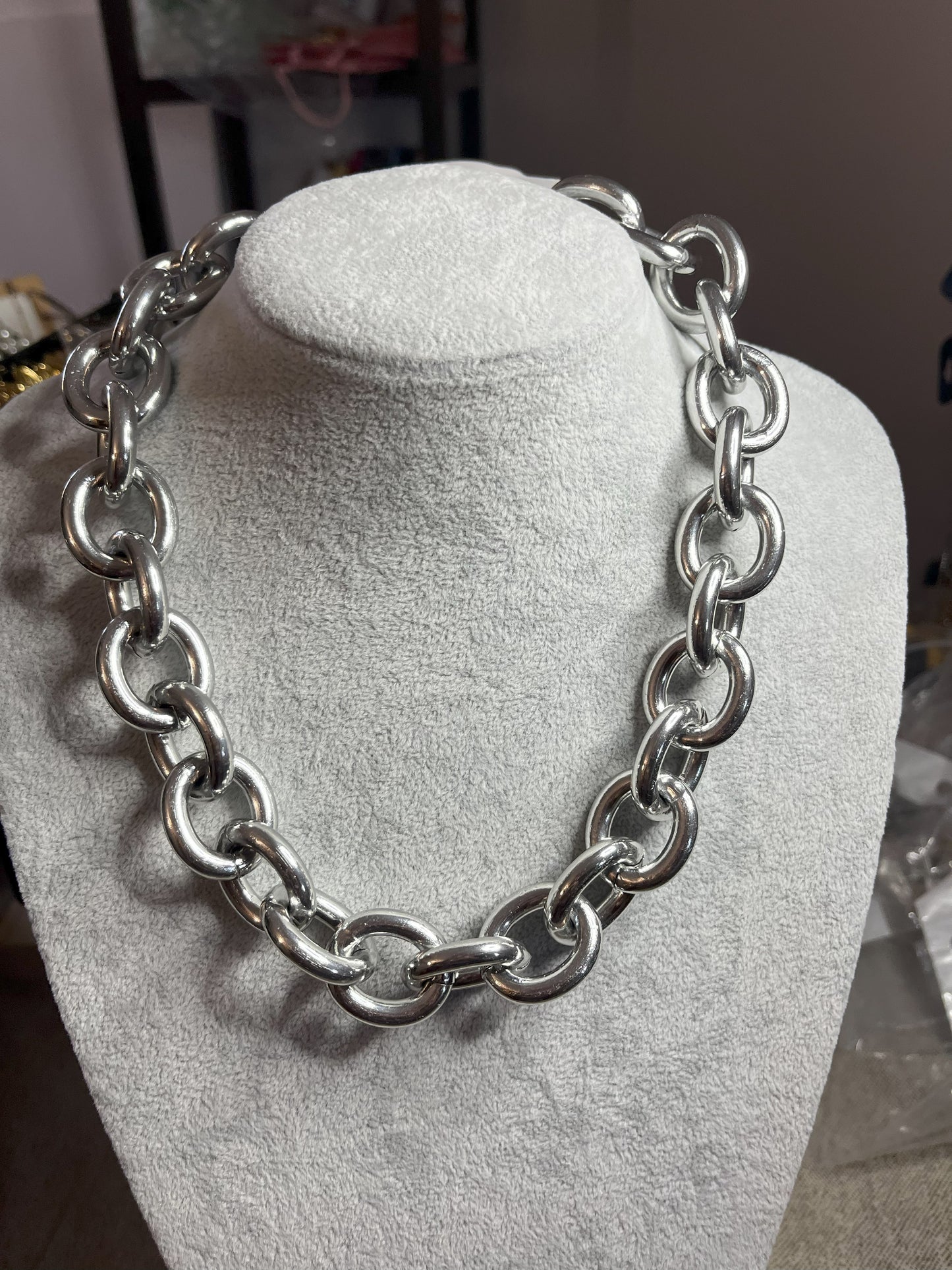 Collana Catena Armonia in alluminio premium con anelli argentati intrecciati su busto espositore, design moderno e elegante