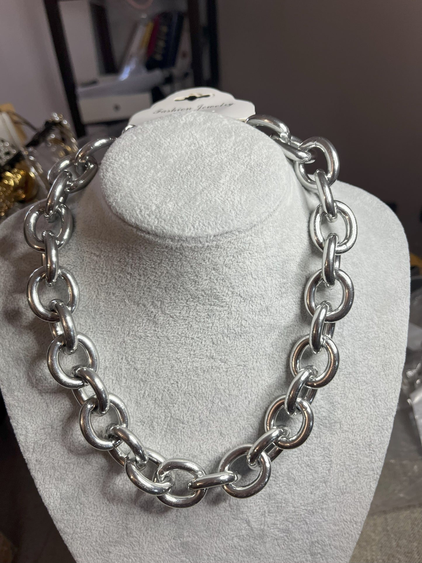 Collana Catena Armonia in alluminio premium con anelli argentati intrecciati su busto espositore, design moderno e elegante