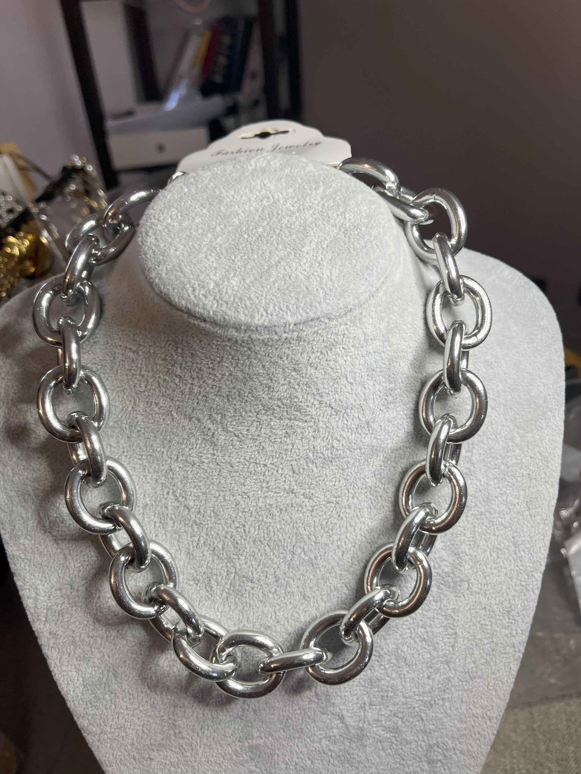 Collana Catena Armonia in alluminio premium con anelli argentati intrecciati su busto espositore, design moderno e elegante