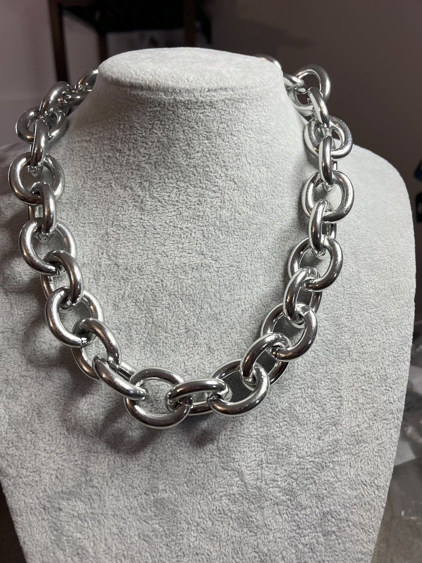 Collana Catena Armonia in alluminio premium con anelli argentati intrecciati su busto espositore, design moderno e elegante