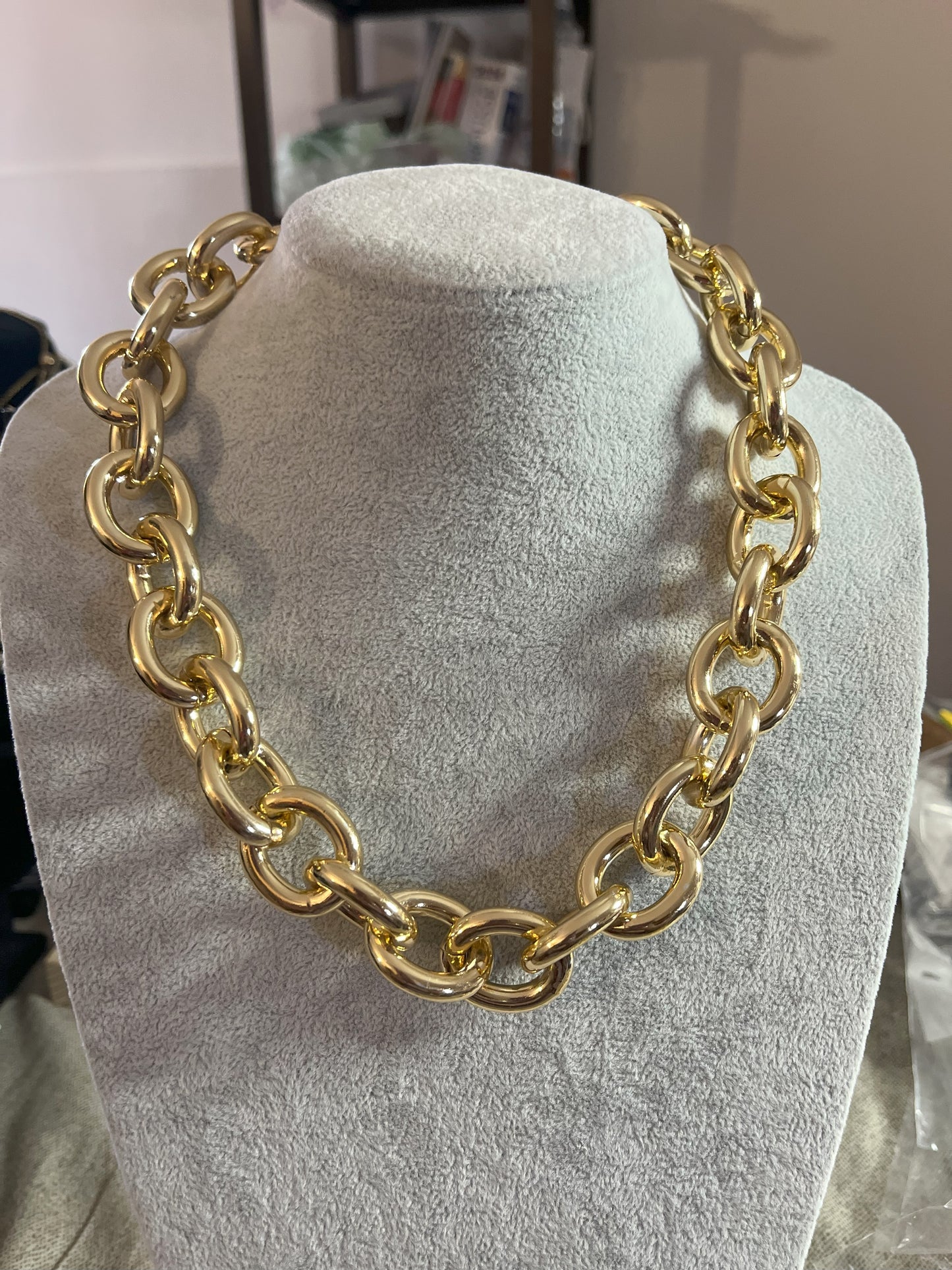 Collana Catena Armonia in alluminio premium con anelli dorati intrecciati su busto espositore, design moderno e elegante