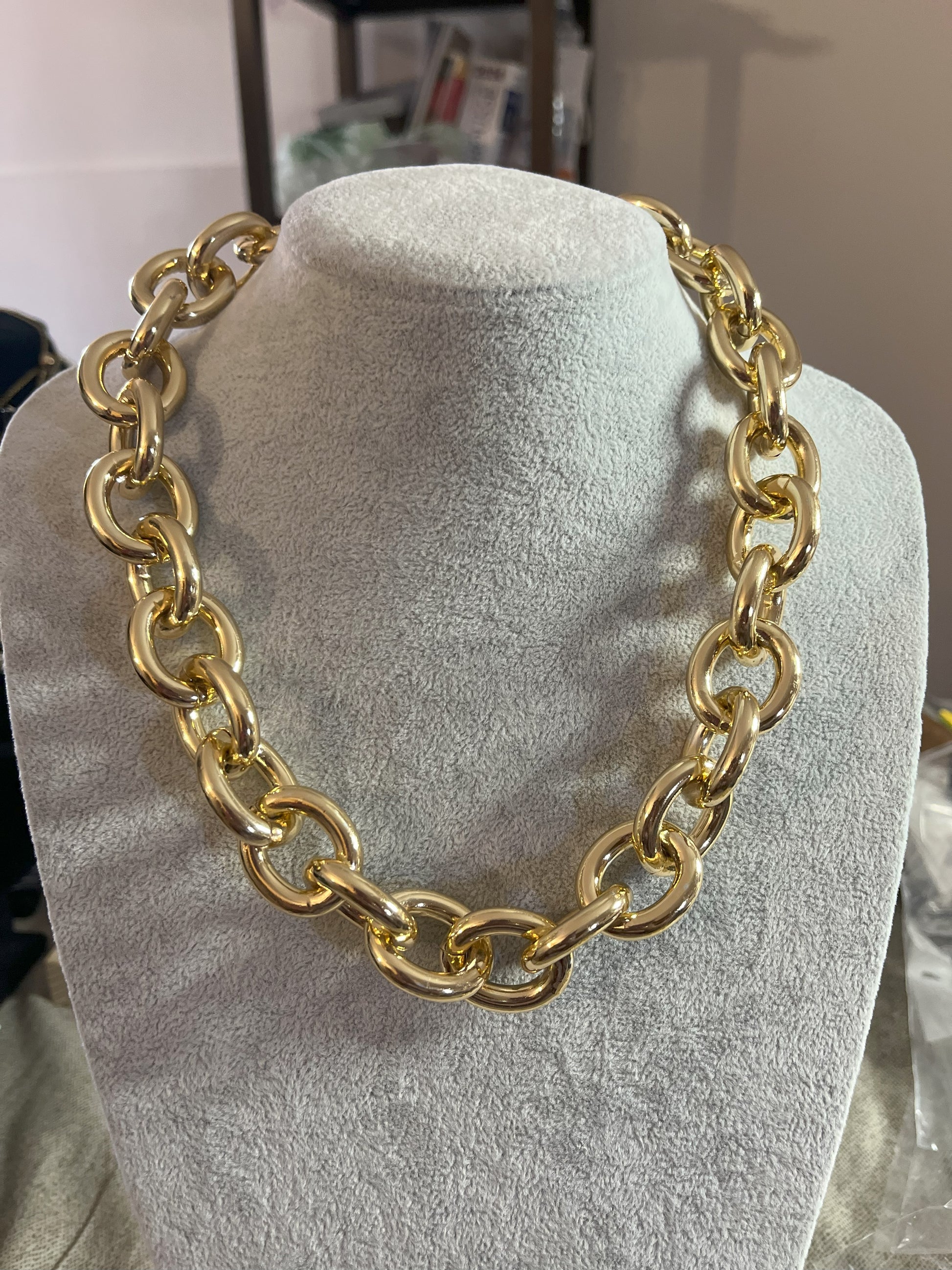 Collana Catena Armonia in alluminio premium con anelli dorati intrecciati su busto espositore, design moderno e elegante