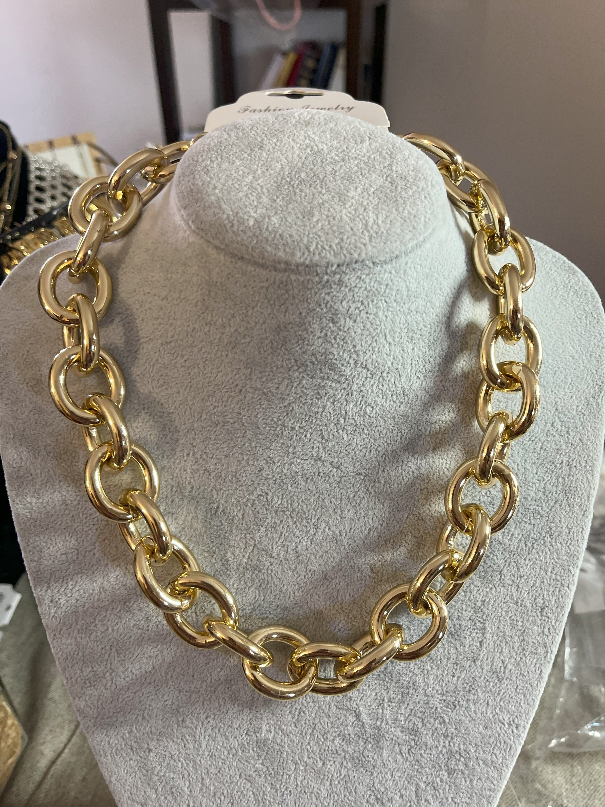 Collana Catena Armonia in alluminio premium con anelli dorati intrecciati su busto espositore, design moderno e elegante