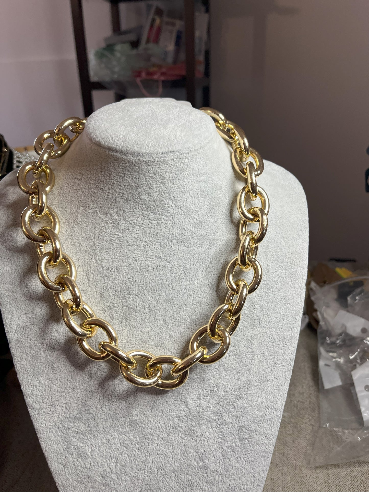 Collana Catena Armonia in alluminio premium con anelli dorati intrecciati su busto espositore, design moderno e elegante