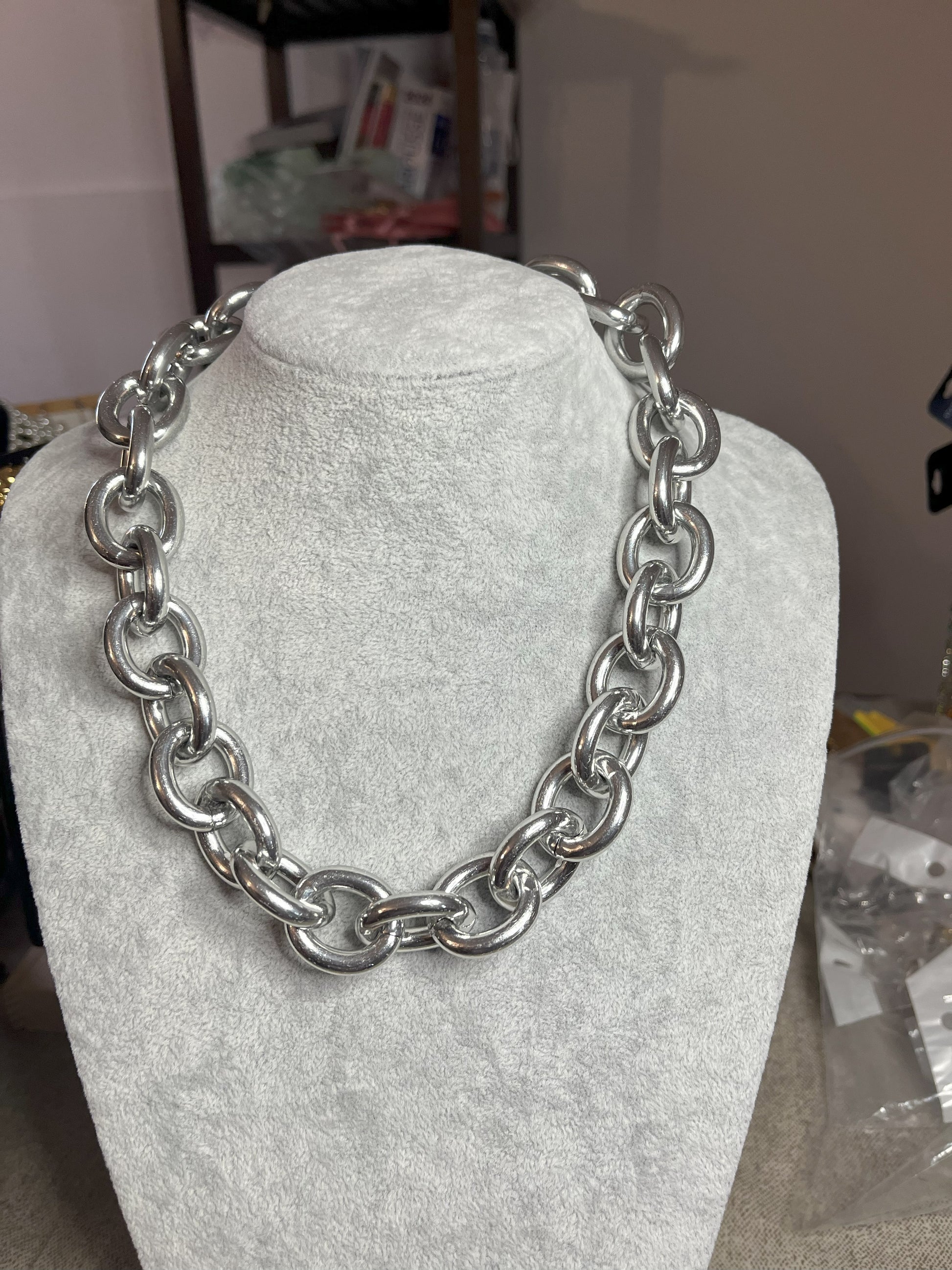 Collana Catena Armonia in alluminio premium con anelli argentati intrecciati su busto espositore, design moderno e elegante