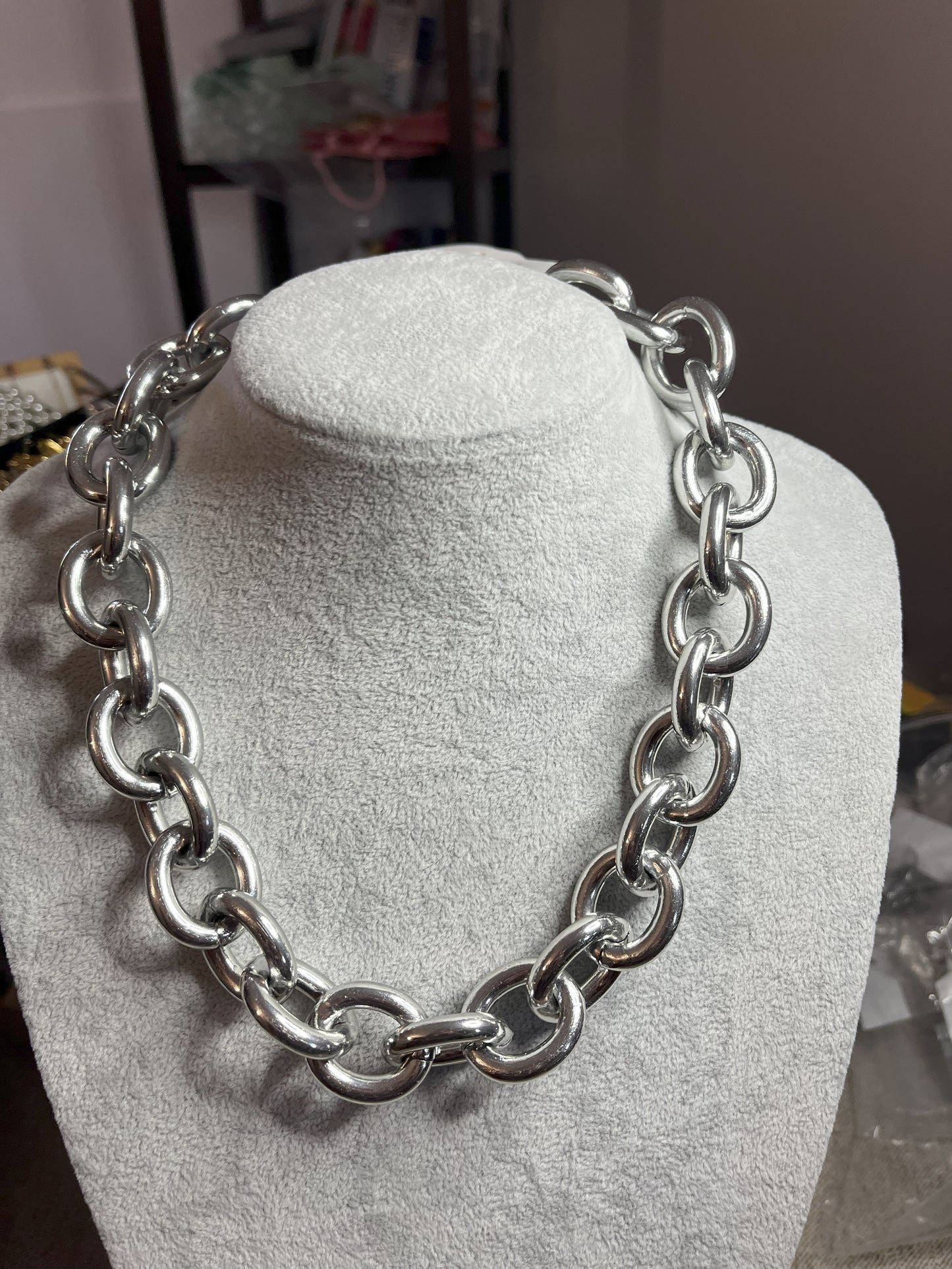 Collana Catena Armonia in alluminio premium con anelli argentati intrecciati su busto espositore, design moderno e elegante