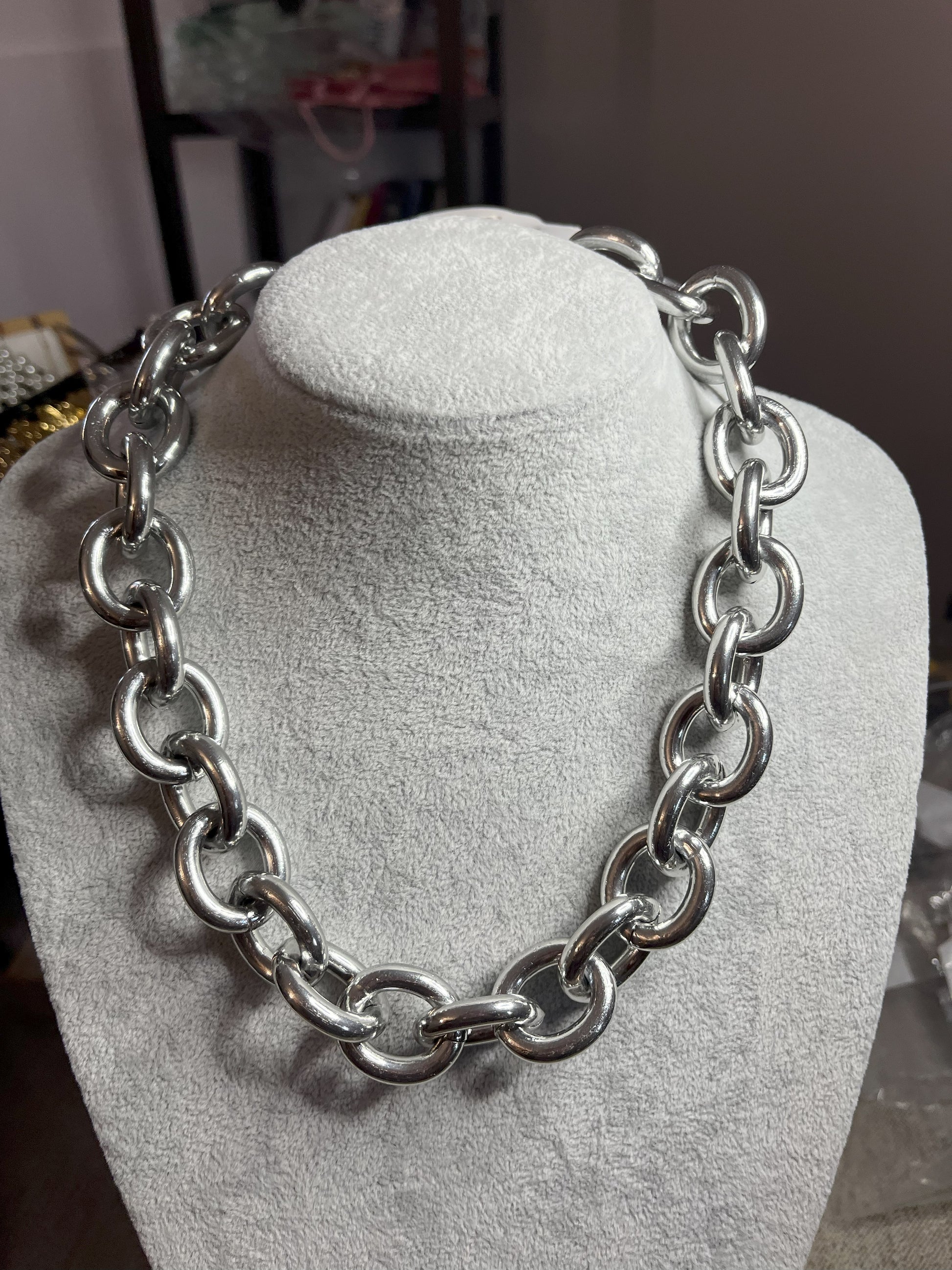 Collana Catena Armonia in alluminio premium con anelli argentati intrecciati su busto espositore, design moderno e elegante