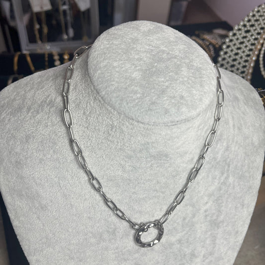 Collana Catena Cerchio in acciaio inox placcato argento con catena a maglie ovali e ciondolo cerchio, esposta su busto grigio