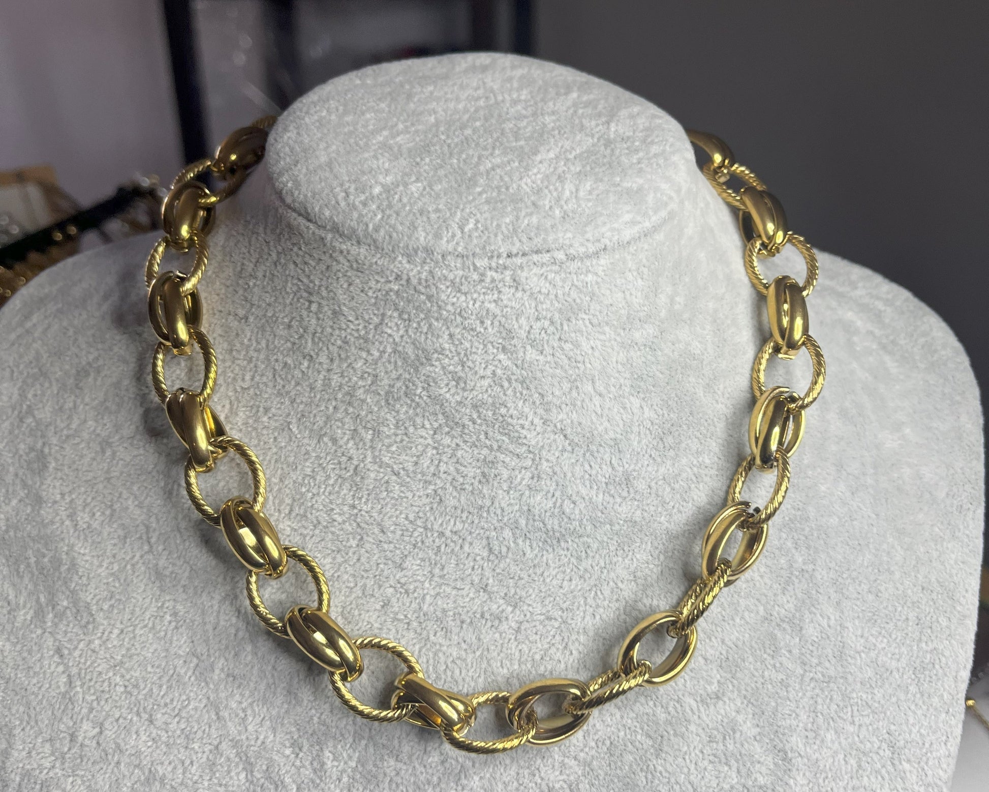 Collana Catena Royale in acciaio 316L con catena a maglie larghe, disponibile in placcatura oro, esposta su busto grigio