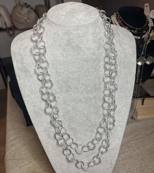 Collana elegante in alluminio placcato argento con doppia catena e cerchi intrecciati, esposta su busto bianco