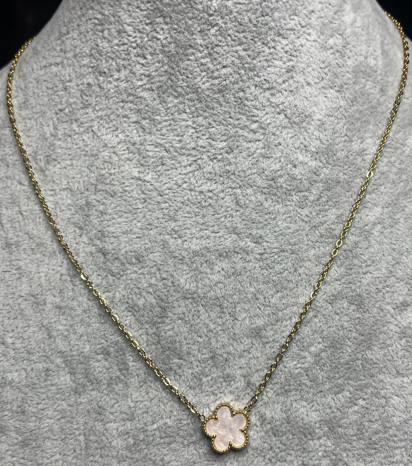 Collana ciondolo stella rosa e catena dorata su busto espositore