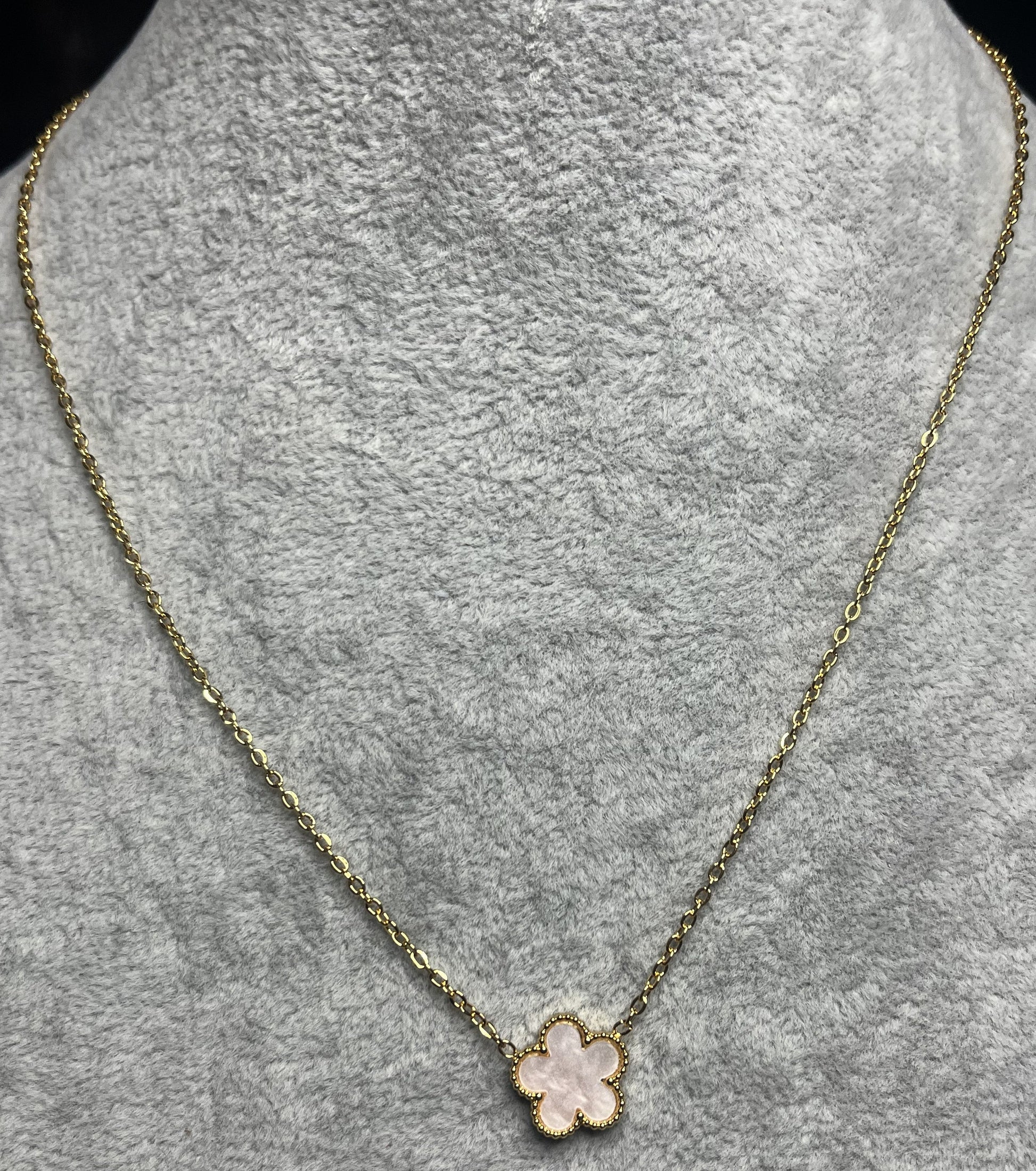 Collana ciondolo stella rosa e catena dorata su busto espositore