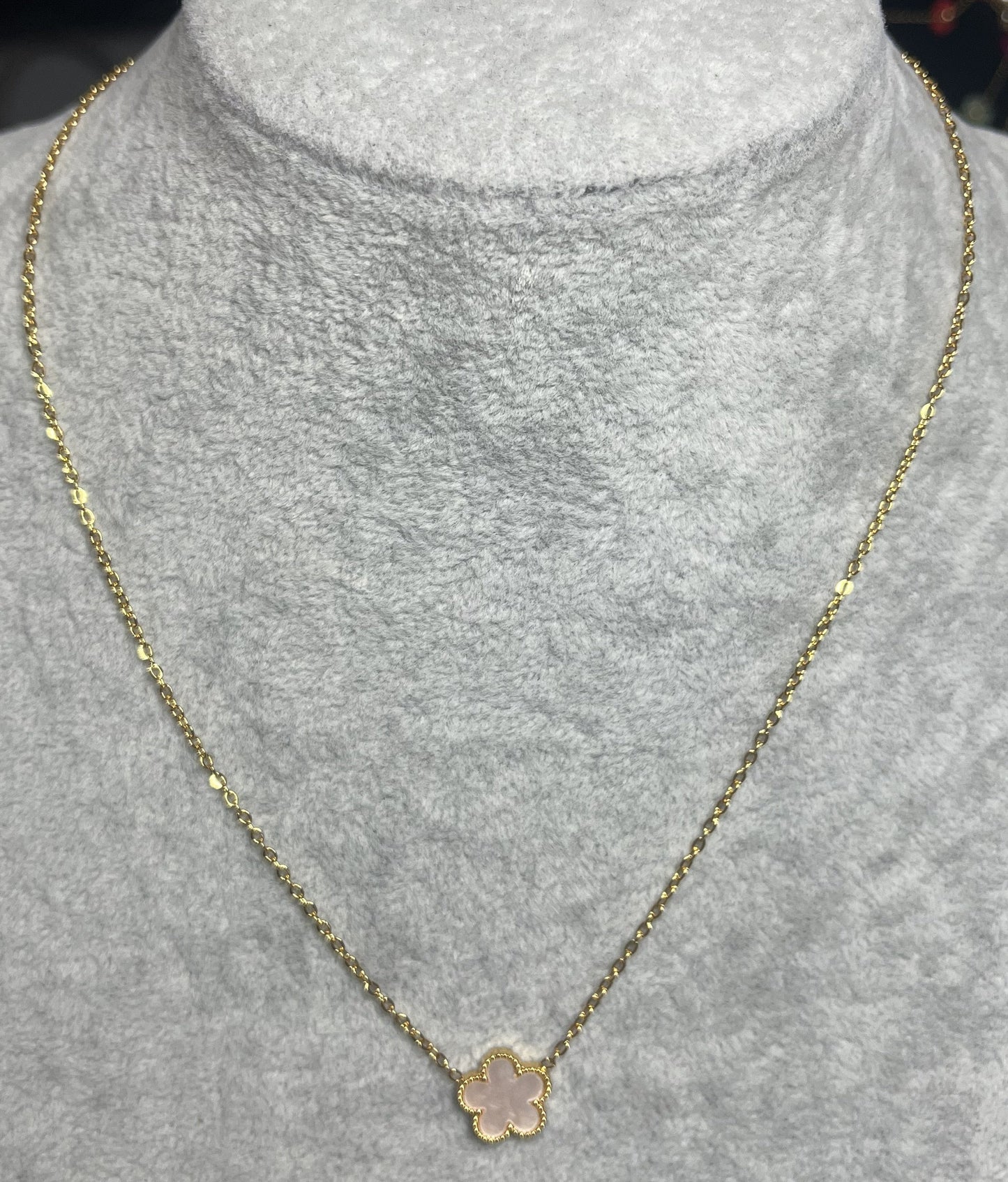 Collana ciondolo stella rosa e catena dorata su busto espositore