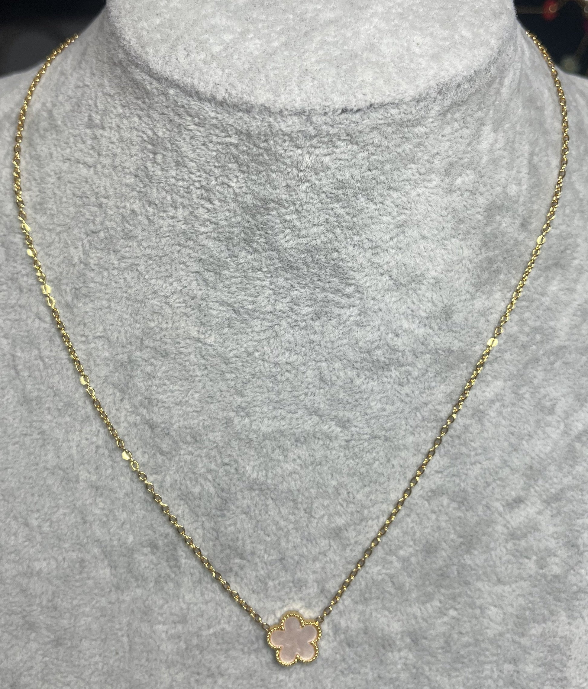 Collana ciondolo stella rosa e catena dorata su busto espositore