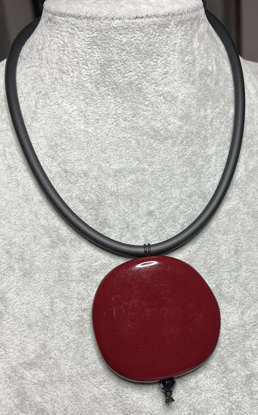Collana con ciondolo rotondo bordeaux in resina su cordino nero in caucciù