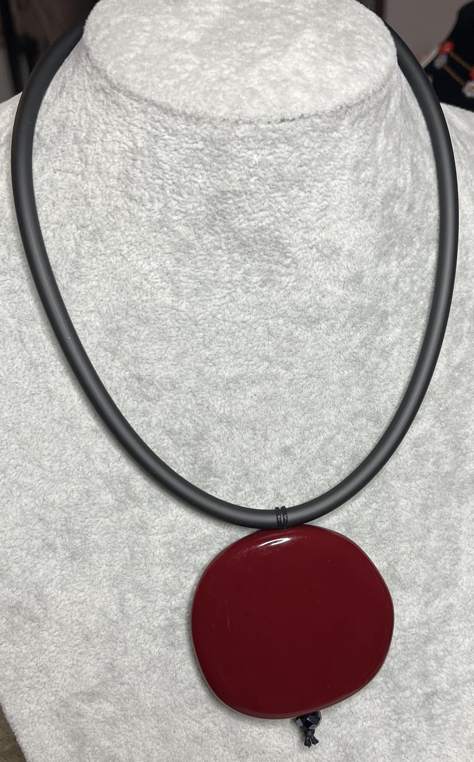 Collana con ciondolo rotondo bordeaux in resina su cordino nero in caucciù