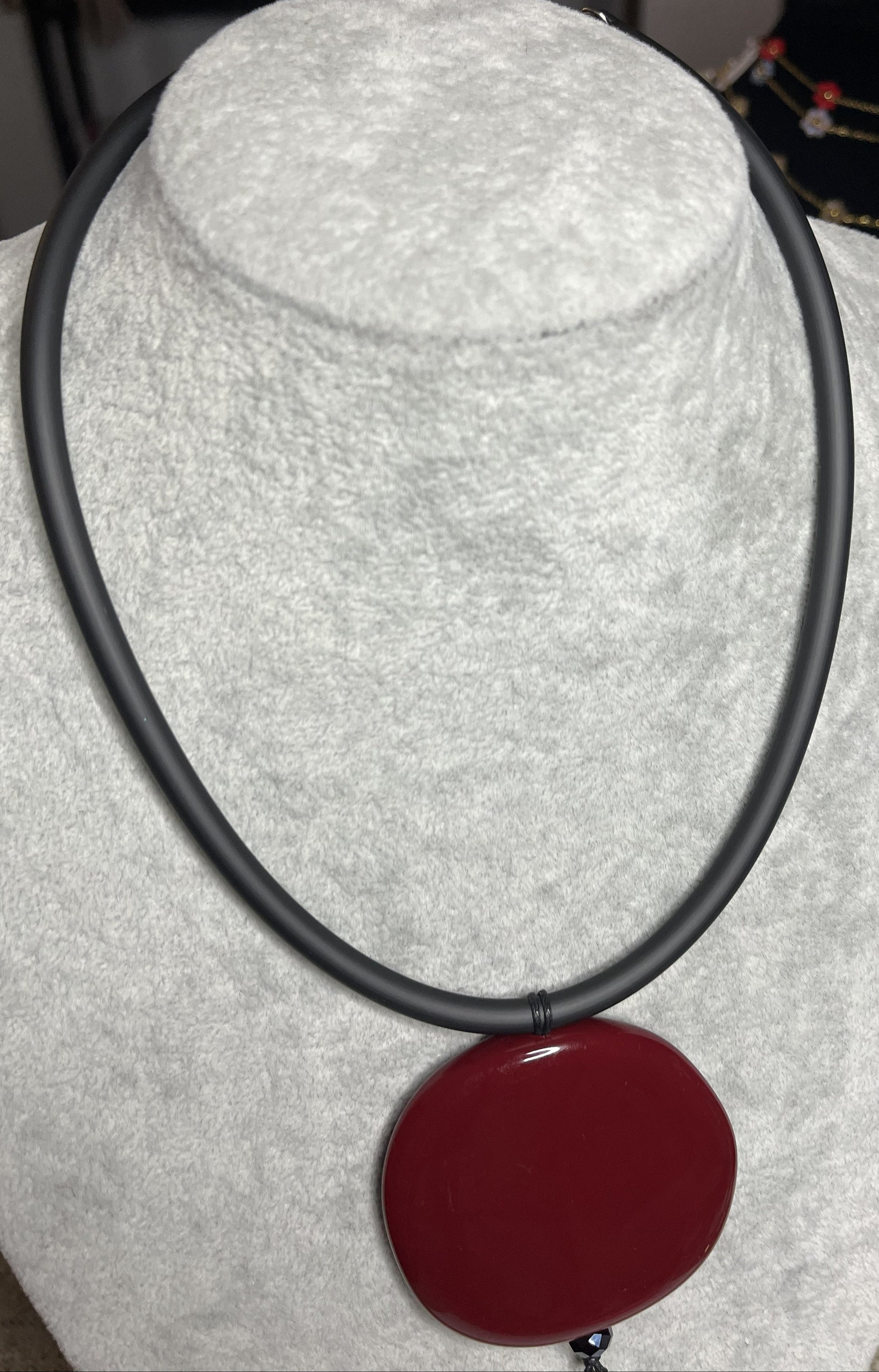 Collana con ciondolo rotondo bordeaux in resina su cordino nero in caucciù